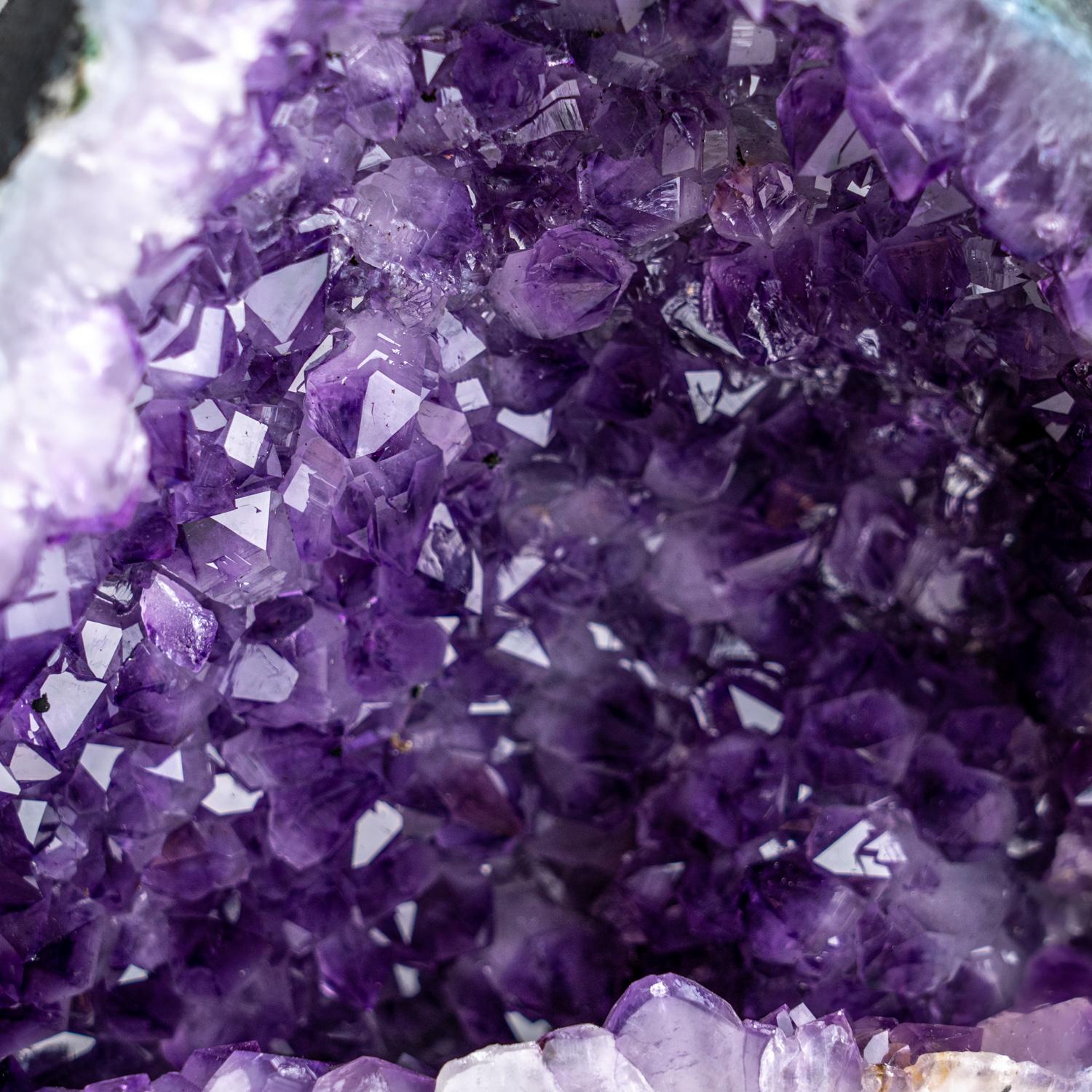 Questo geode a grappolo di ametista autentica proveniente dall'Uruguay è una formazione naturale di ametista di prima qualità. Il mezzo geode a cattedrale è caratterizzato da lucenti cristalli completamente terminati con facce altamente riflettenti