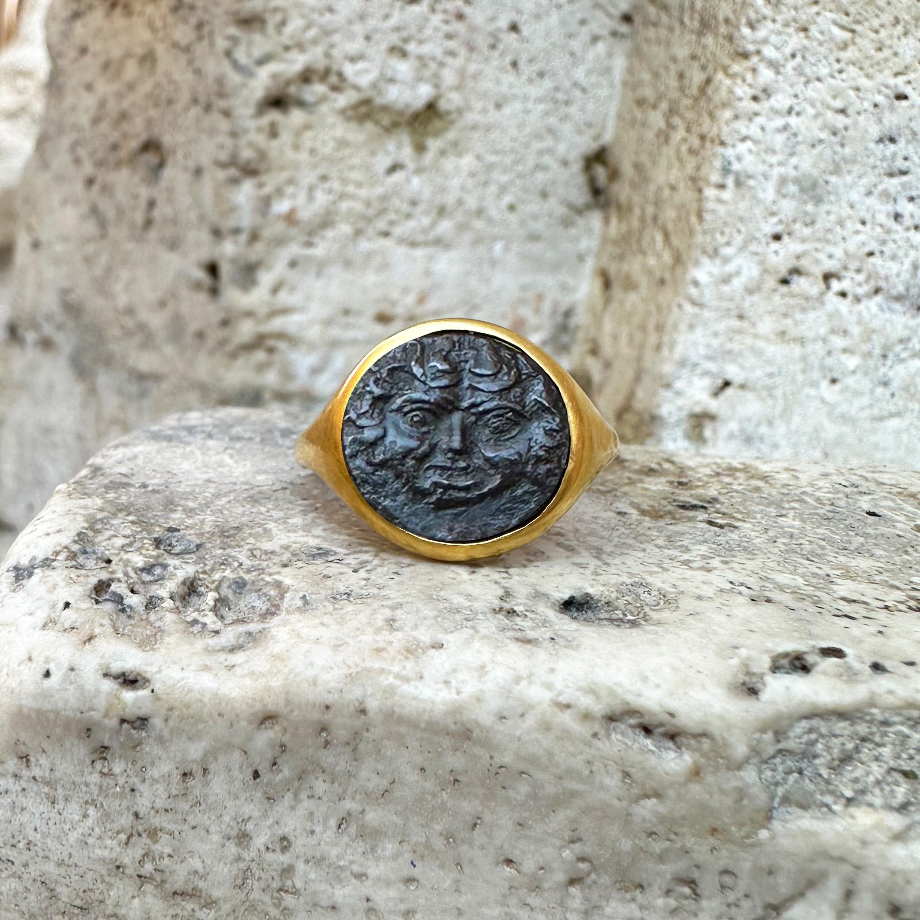 This exquisite 18 kt gold ring features an authentic bronze Greek coin from 420-405 BC, adorned with a striking depiction of the Gorgon, a mythical figure steeped in ancient lore.

 In Greek mythology, Gorgons, including the infamous Medusa, were