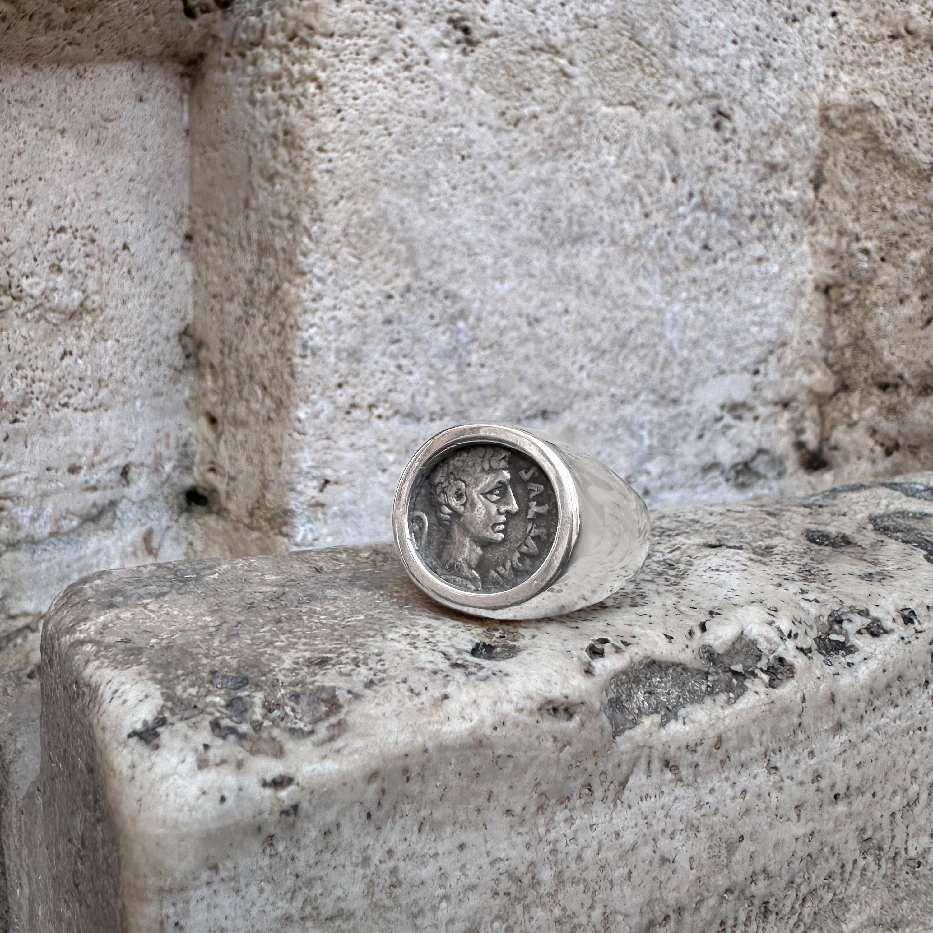 Este anillo de plata de ley contiene una moneda romana auténtica que representa al emperador Cayo Julio César Octavio Augusto (comúnmente conocido como Octavio o Augusto), considerado el fundador del Imperio Romano y su primer emperador, que reinó