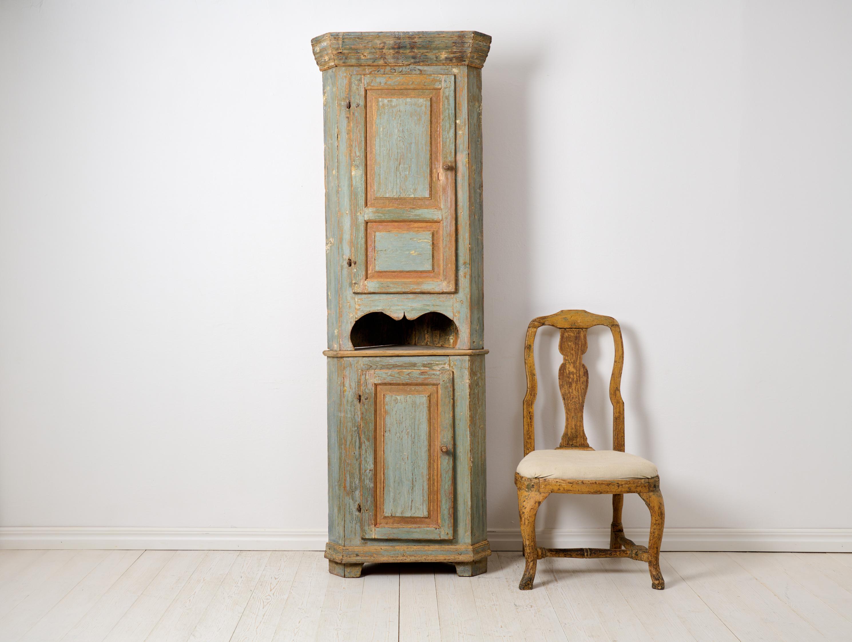 Unusual country corner cabinet from northern Sweden. The cabinet is a genuine country house furniture and is very unusual. It is made very tall and narrow, please refer to the measurements. Made in two parts and dry scraped by hand down to the first
