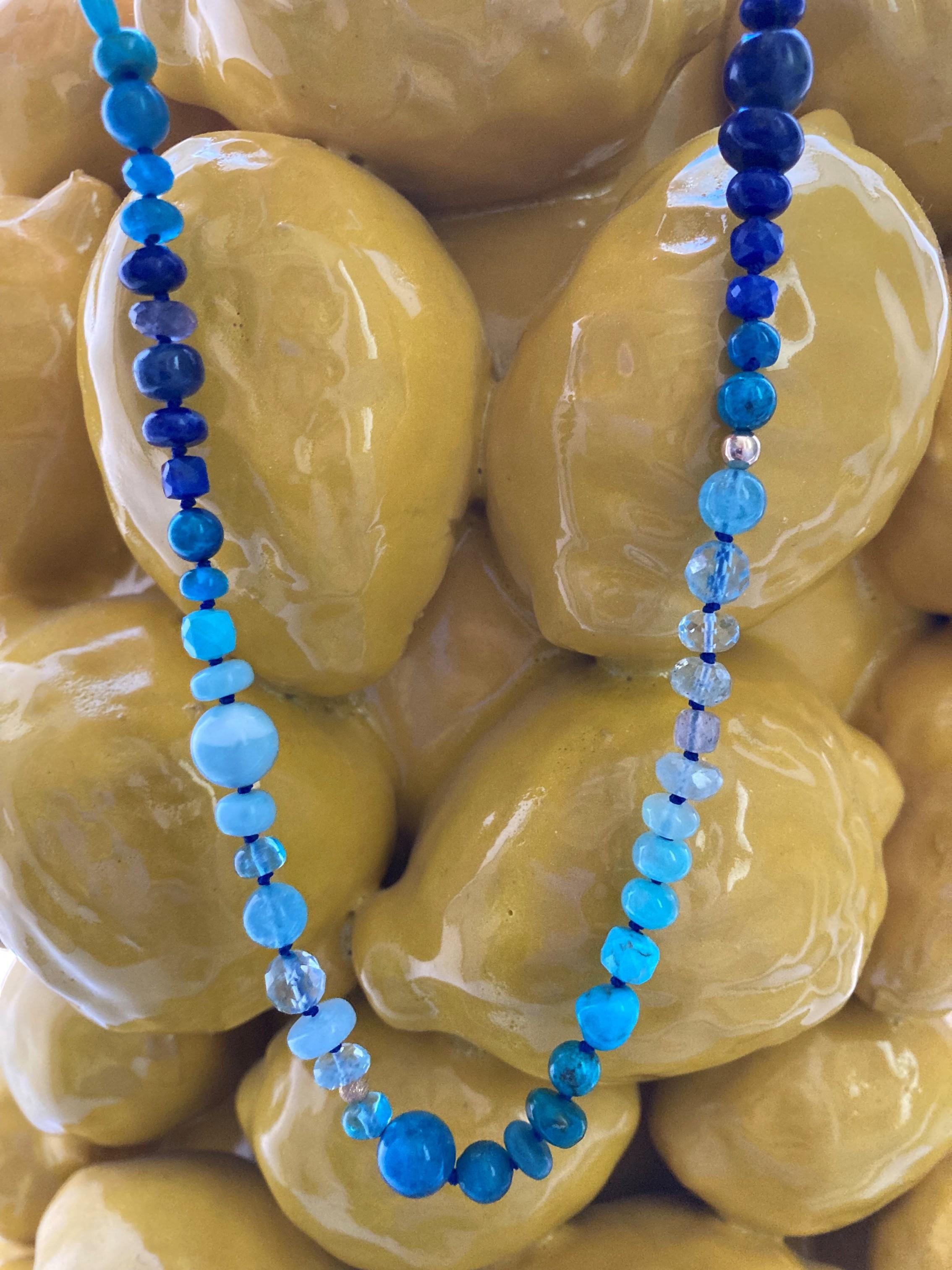 Embrace yourself with blue sparkling gemstones that create a seabreeze around your neck. The facetted shapes of the stones enhance this necklace’s beauty, with precious stones featuring facetted cuts and different shapes that catch the light in