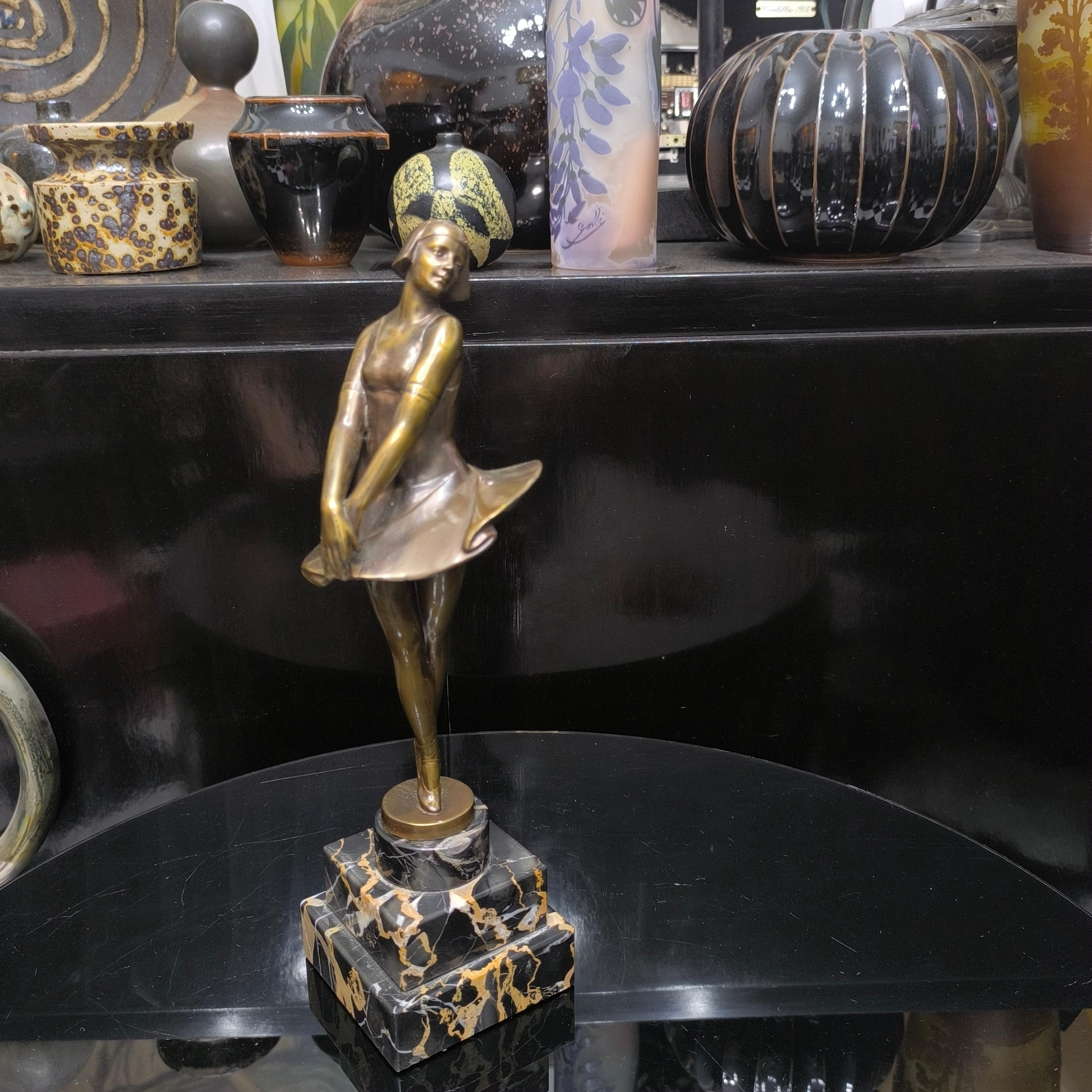 A rare and refined piece that channels the elegance of early 20th-century ballet and fashion.
In the style of Demétre Chiparus or Josef Lorenzl, this sculpture captures the elegance and theatricality of a ballerina mid-motion. 
Her flared dress and