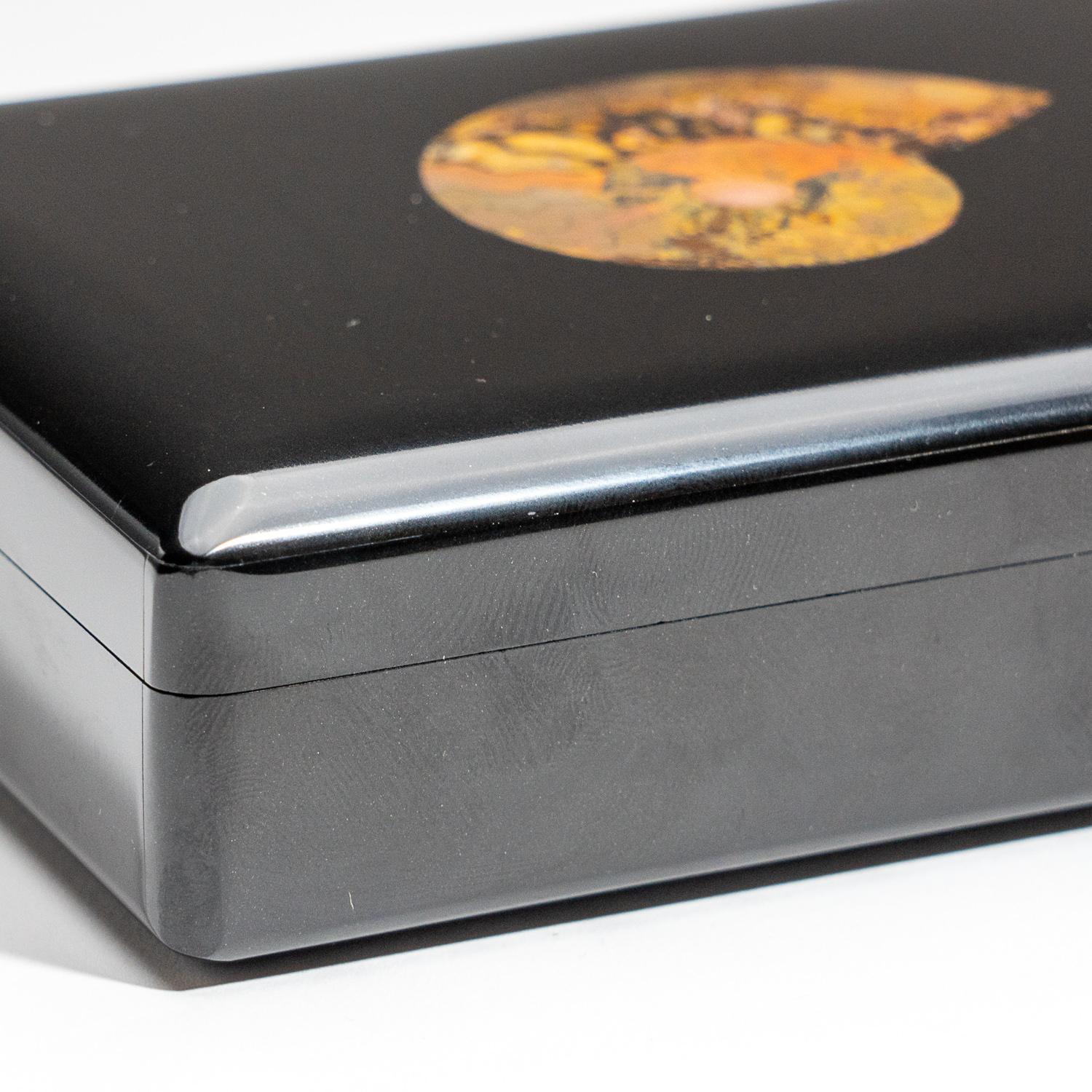 Large rectangle jewelry box handmade from the finest top grade black onyx with rich jet black color and decorated with ammonite fossil. The box has been hand polished to a mirror finish. The lid has a piano hinge opening to reveal a black velvet