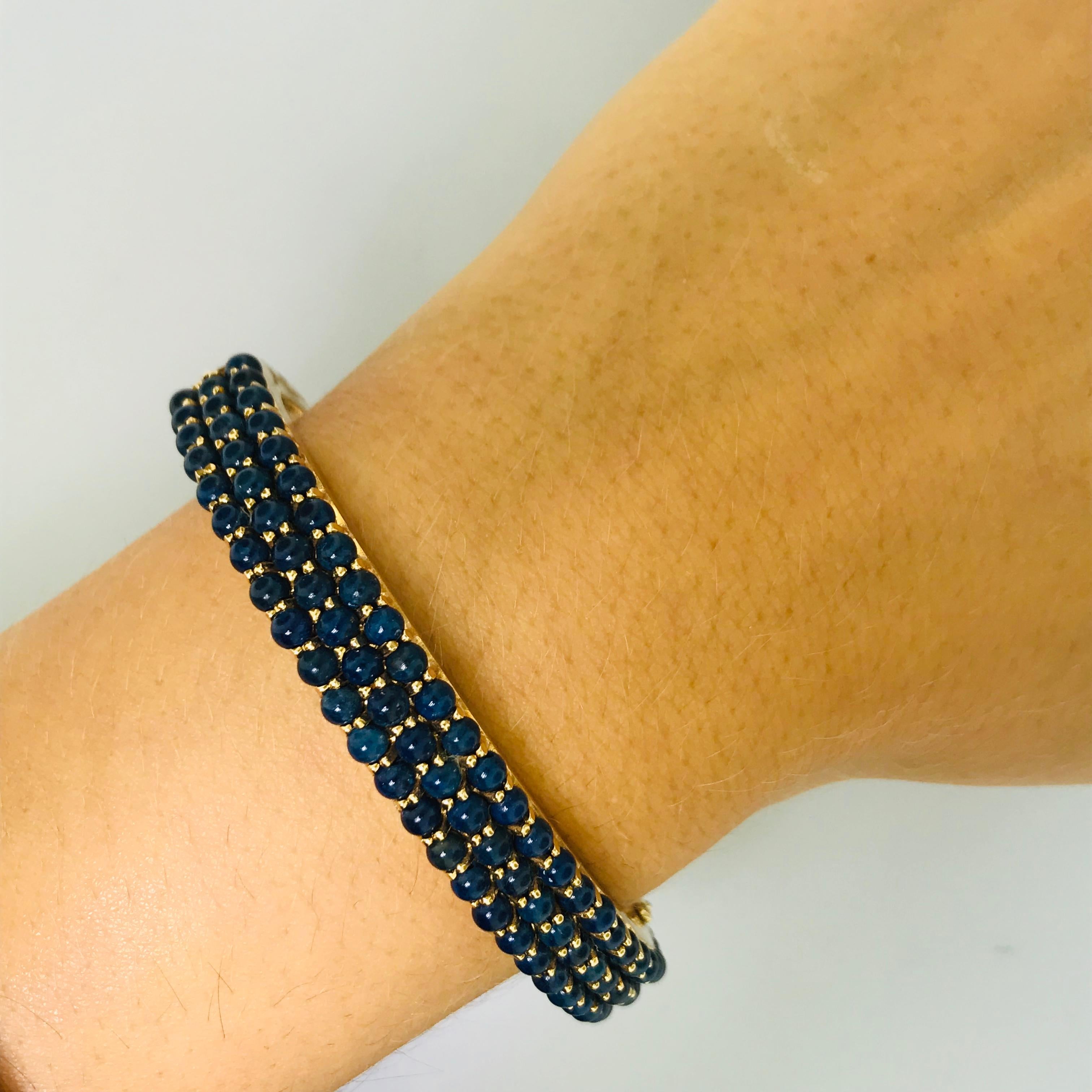 This bangle bracelet is unique and vintage. With genuine blue lapis covering the front there is an interesting texture that gives this bracelet personality. Each blue lapis is a round piece that is 3 mm. The bangle is 14k yellow gold and has been