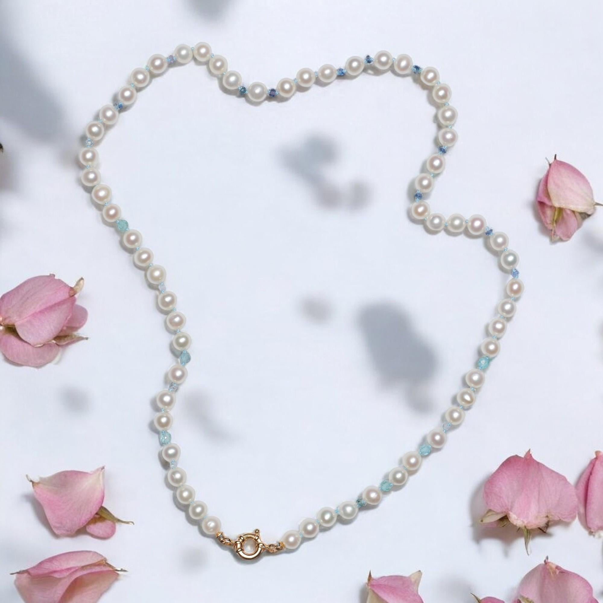 Methiciously hand knotted blue sapphire and white shiny freshwater pearls necklace, finished with a solid gold 14k clasp. The hand carved sparkling precious stones vary from a deep -to a vivid sky blue color. Furthermore this classic necklace is