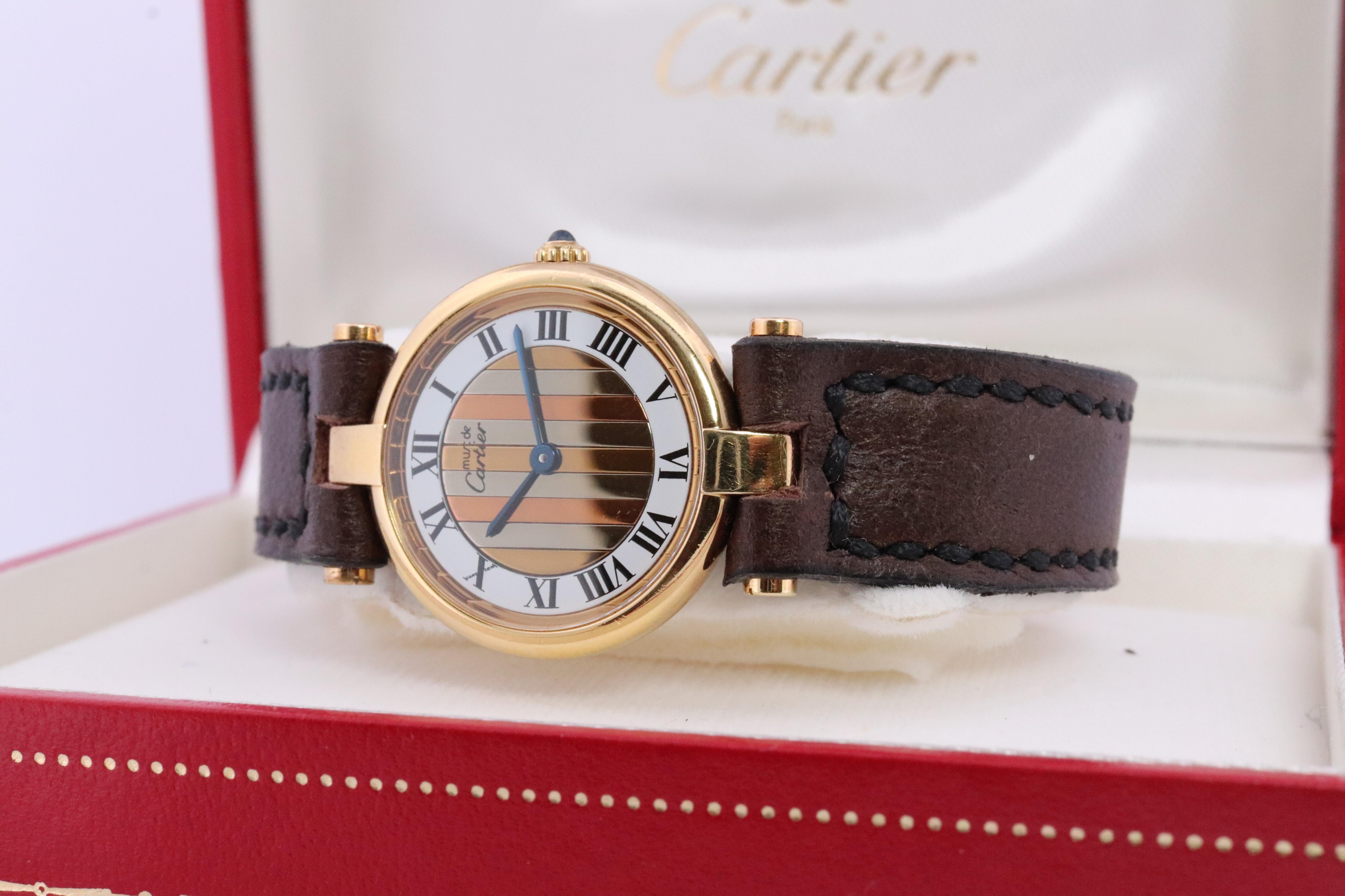 Echte Cartier Uhr.

Vintage Must de Cartier Vendome

Trinity Tricolor Gesicht. Weiß, Gold und Roségold.

Saphir-Cabochon-Krone.

Zustand: Kommt mit Cartier Fall. Die Abnutzung entspricht dem Alter. Neues handgefertigtes braunes Lederband. Original