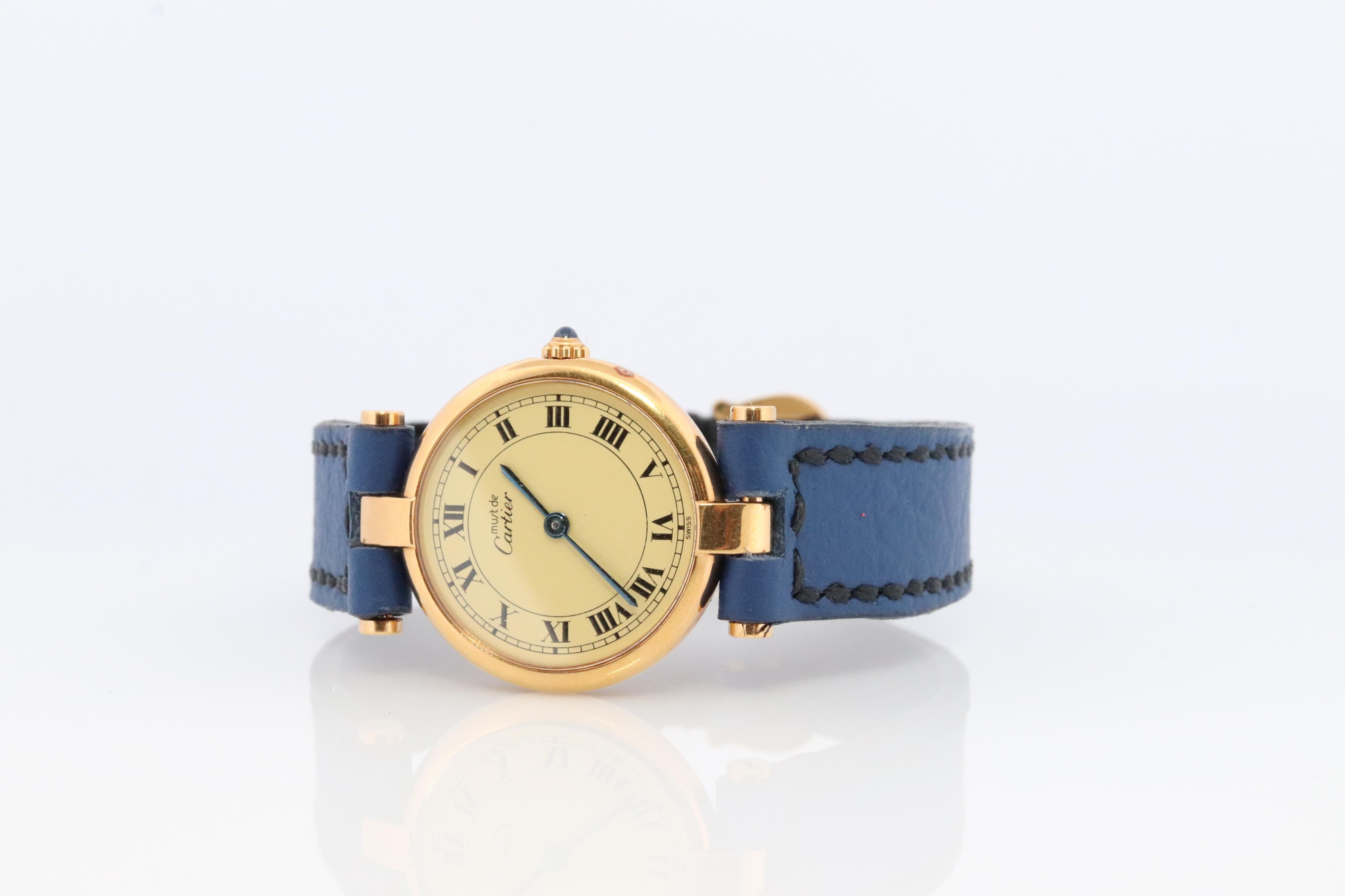 Genuine Cartier watch.

Vintage Must de Cartier Vendome

Cream White dial.

Sapphire Cabochon Crown.

Condition: Comes with Cartier case. Wear consistent with age. New Handcrafted Blue Leather Band. Original Cartier Buckle. 

Choice of Strap color.
