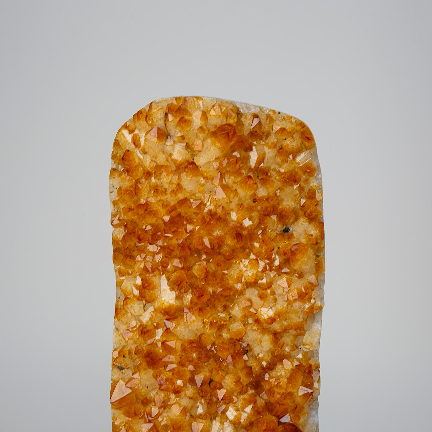 This 16.5 lb Genuine Citrine Quartz Crystal Cluster from Brazil is a remarkable beauty. The free-form cluster is adorned with perfectly shaped crystal points, displaying stunning hues of orange and yellow. Resting on a cement base, this mineral