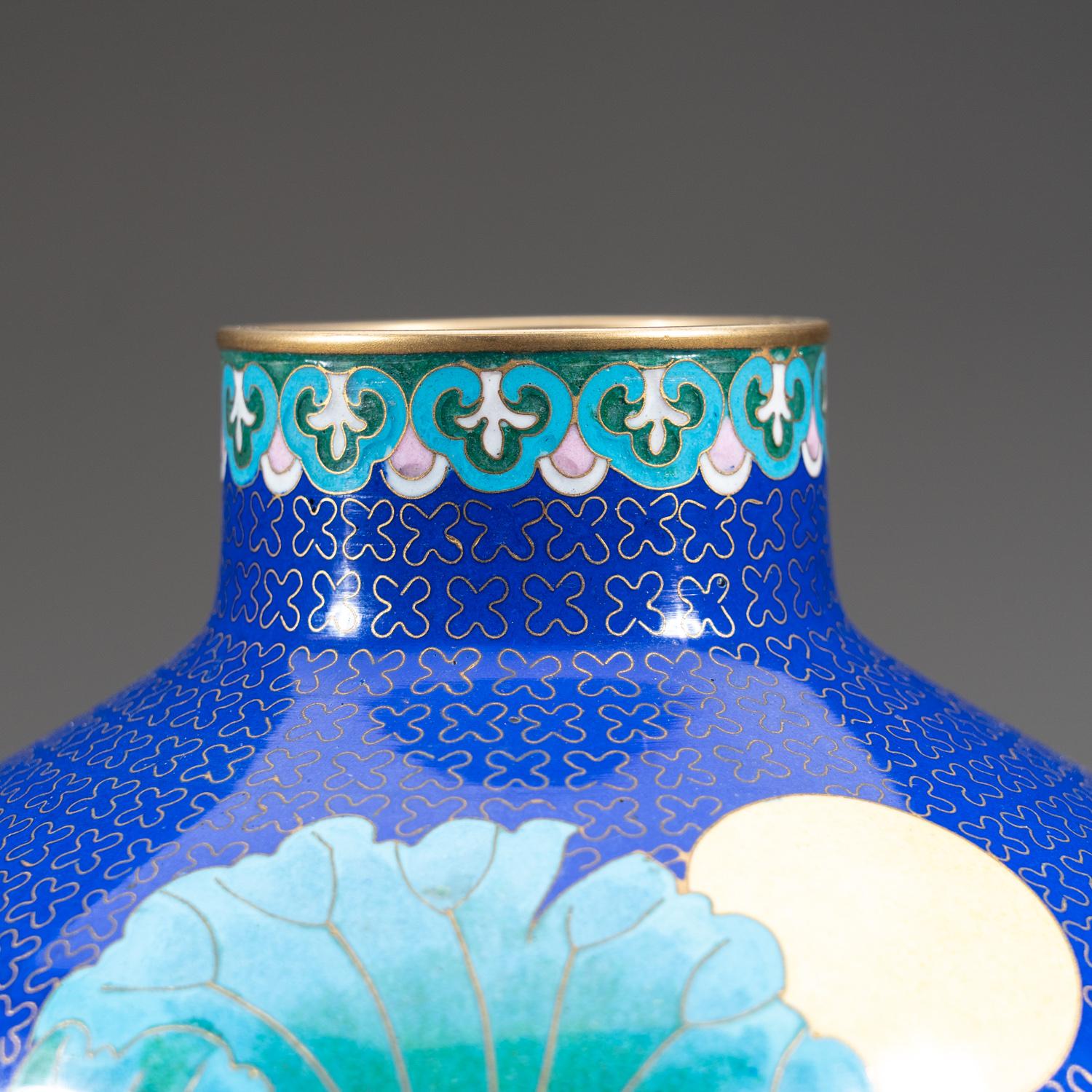 A blue cloisonné vase depicting an imperial Woman floating on a river among colorful Birds and Lillies on a celest blue background with a geometric gilt copper/bronze wire design.

Weight: 5.1 lbs, Dimension: 6.5 x 6.5 x 8 inches.

