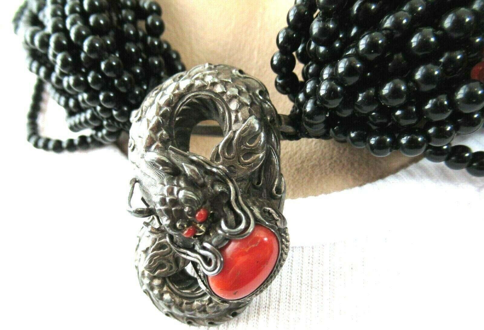 Simply Beautiful Designer Multi Strand Black Onyx and Coral Beads Necklace, suspending a Silver Dragon holding a securely set Coral stone. Seahorse logo on clasp and reverse marked SILVER. Silver tone mountings. Necklace measures approx. 20