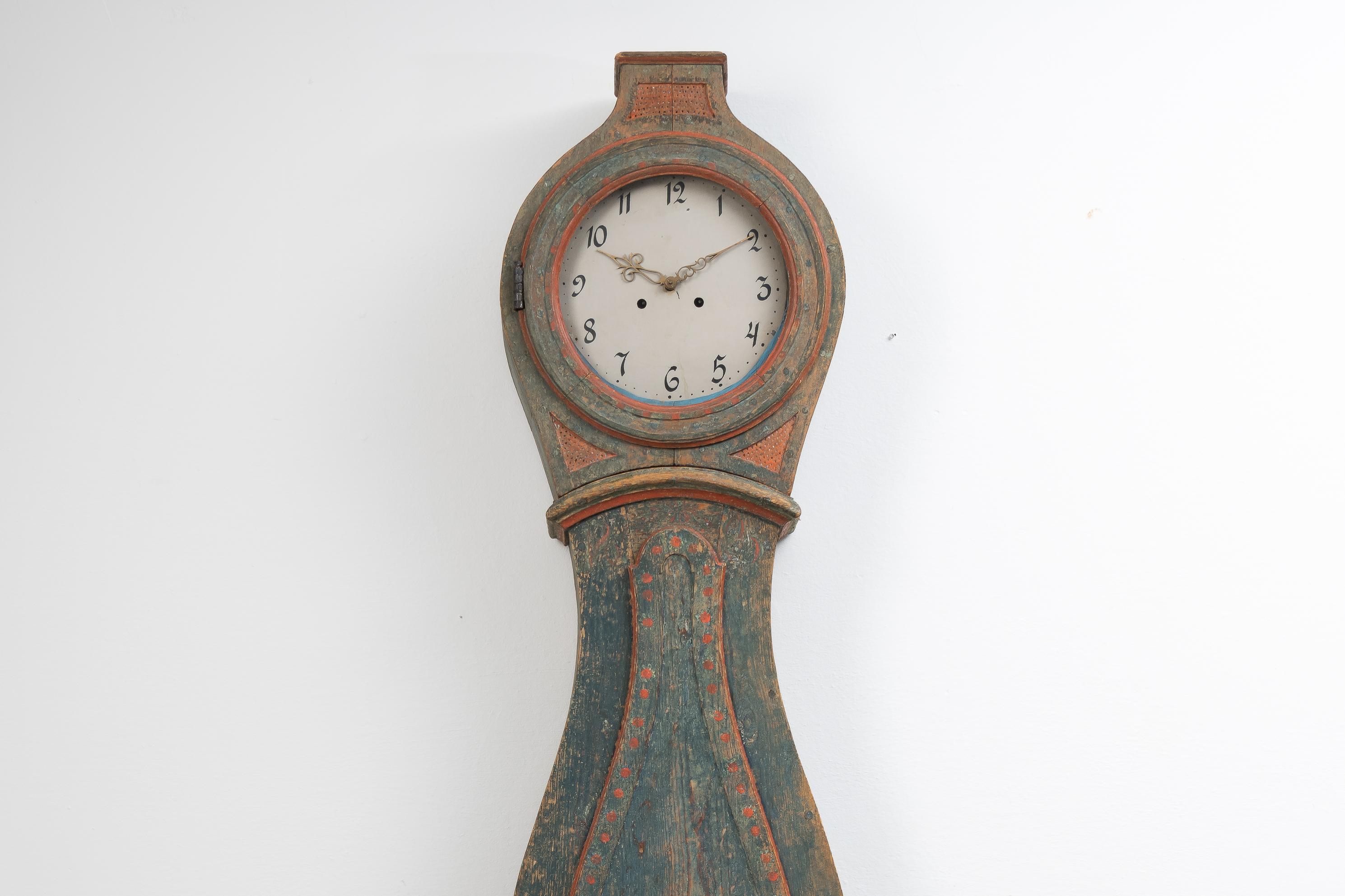 Véritable horloge suédoise à long boîtier du Hälsingland. L'horloge est authentique et honnête avec un boîtier traditionnellement fait à la main avec une forme rococo. Fabriqué en pin suédois avec la peinture bleue verte et la peinture décorative