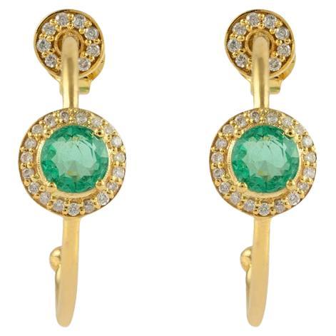 Erhöhen Sie Ihre Eleganz mit diesen exquisiten Ohrringen aus 14-karätigem Gelbgold. Der grüne Smaragd im Rundschliff hat ein Gesamtgewicht von 1 Karat und ist von einem schillernden Diamantenkranz umgeben. Das offene Design verleiht der zeitlosen