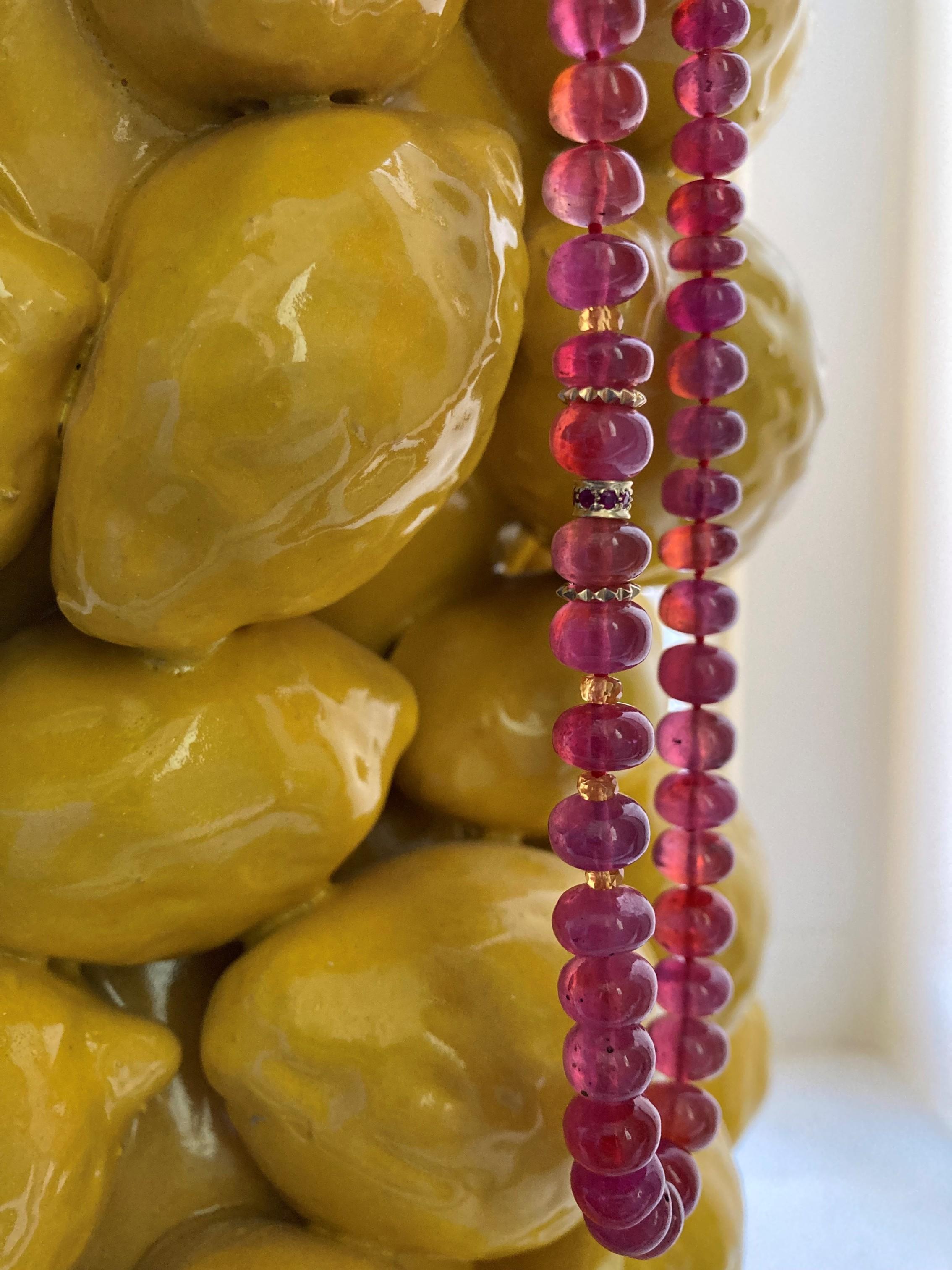 Add a mesmerizing touch to any outfit with this pure deep redish pink ruby beaded necklace in 14K yellow gold. 
This stunning necklace is made with high carat 14K yellow gold hand carved sparkling beads, orange mandarin garnet and features a