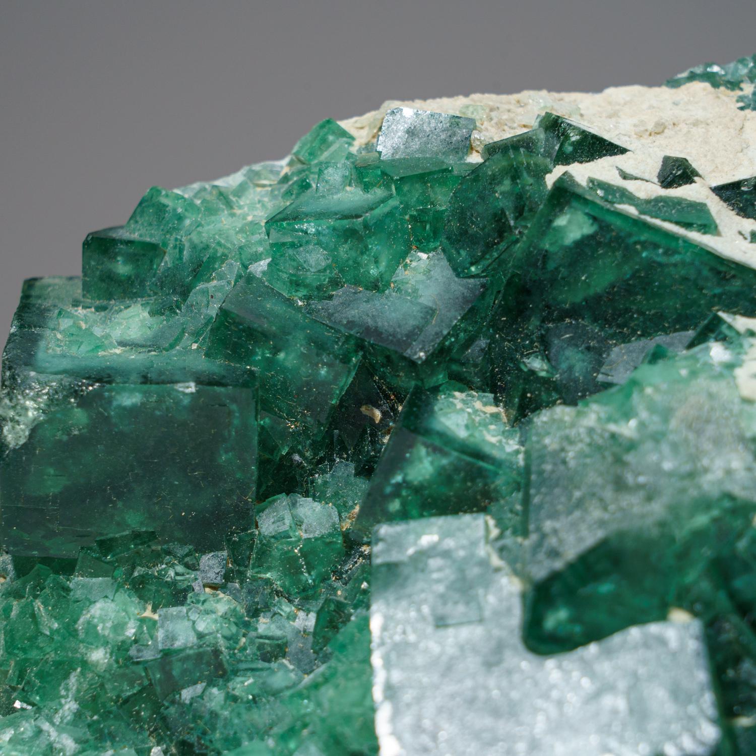 Transparent green cubic fluorite crystals with slightly textured crystal faces that are composed of microscopic octahedral faces. The bright green color is very good for this classic locality that usually produces darker purple-green fluorite.

