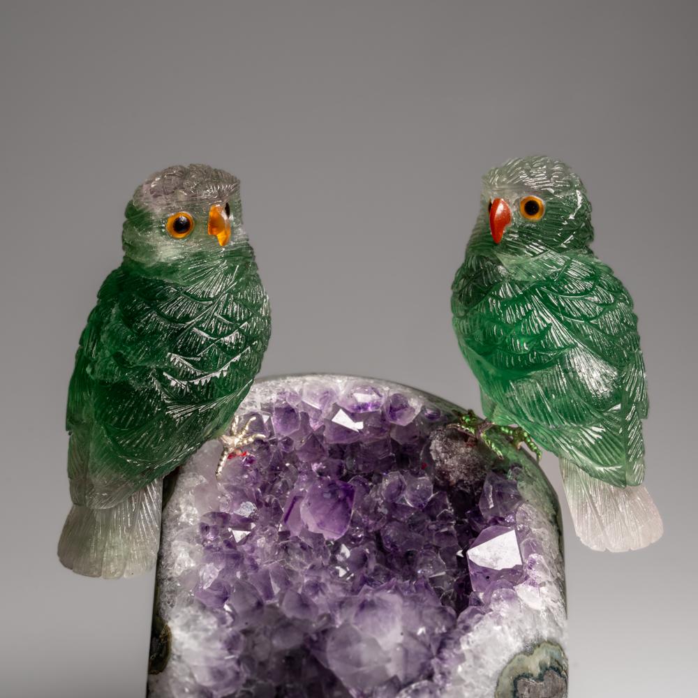 Cette sculpture de hibou est une œuvre d'art unique, sculptée dans de la fluorine de qualité musée, avec des yeux en onyx et un bec en cornaline. Le hibou est perché au sommet d'une matrice de géodes en améthyste et monté sur un support personnalisé