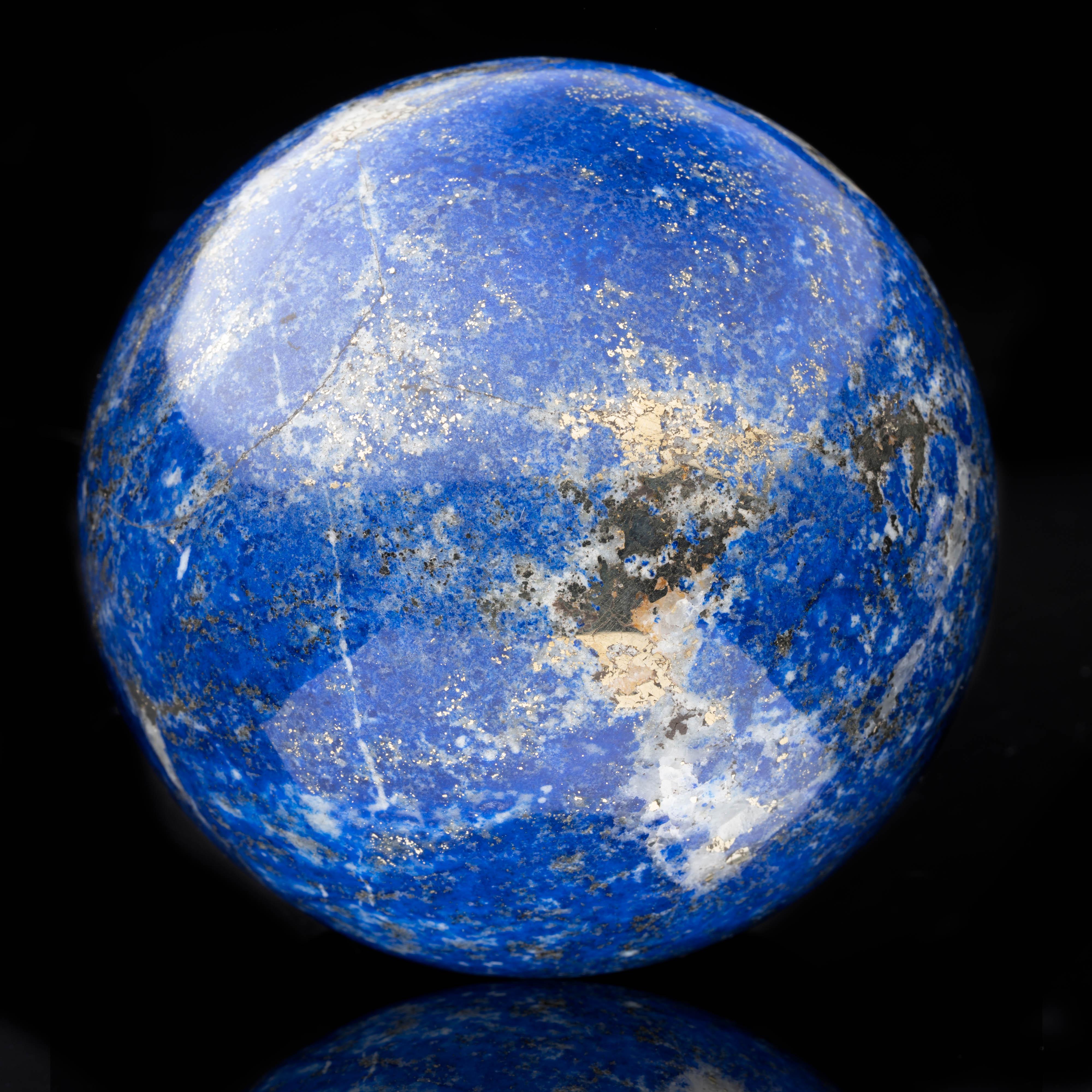 This genuine top-grade 2.29-pound lapis lazuli sphere has been hand-carved and hand-polished out of one solid piece of the best color lapis available. From Afghanistan, this specimen features dazzlingly reflective pyrite deposits over a generous