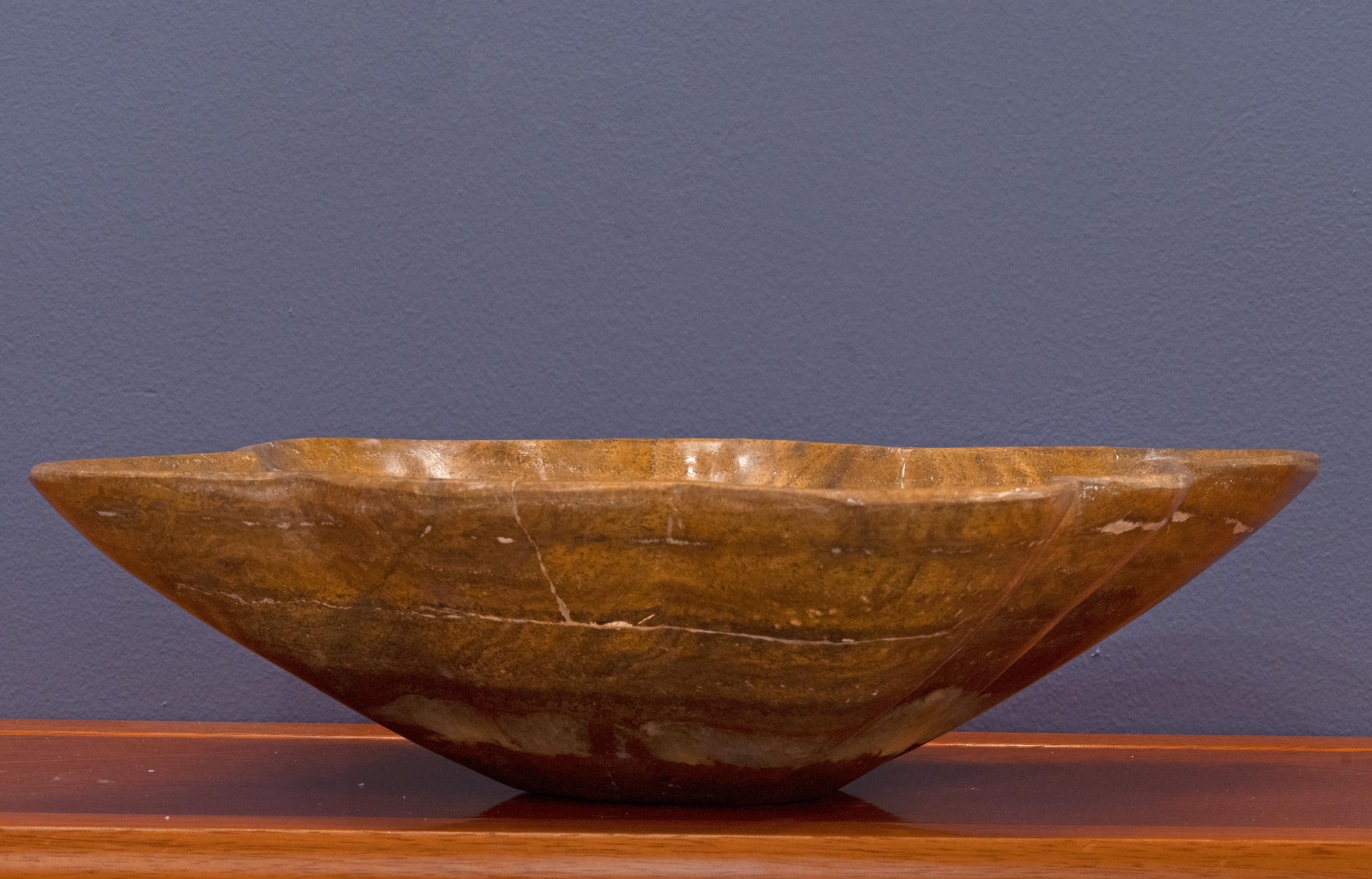 This gorgeously hand-carved 7 pound genuine onyx freeform bowl from Pakistan features a rich mahogany base hue accented by off-white that concentrates in the bottom of the bowl for a contrasting pale, semi-translucent pop. This bowl – the perfect