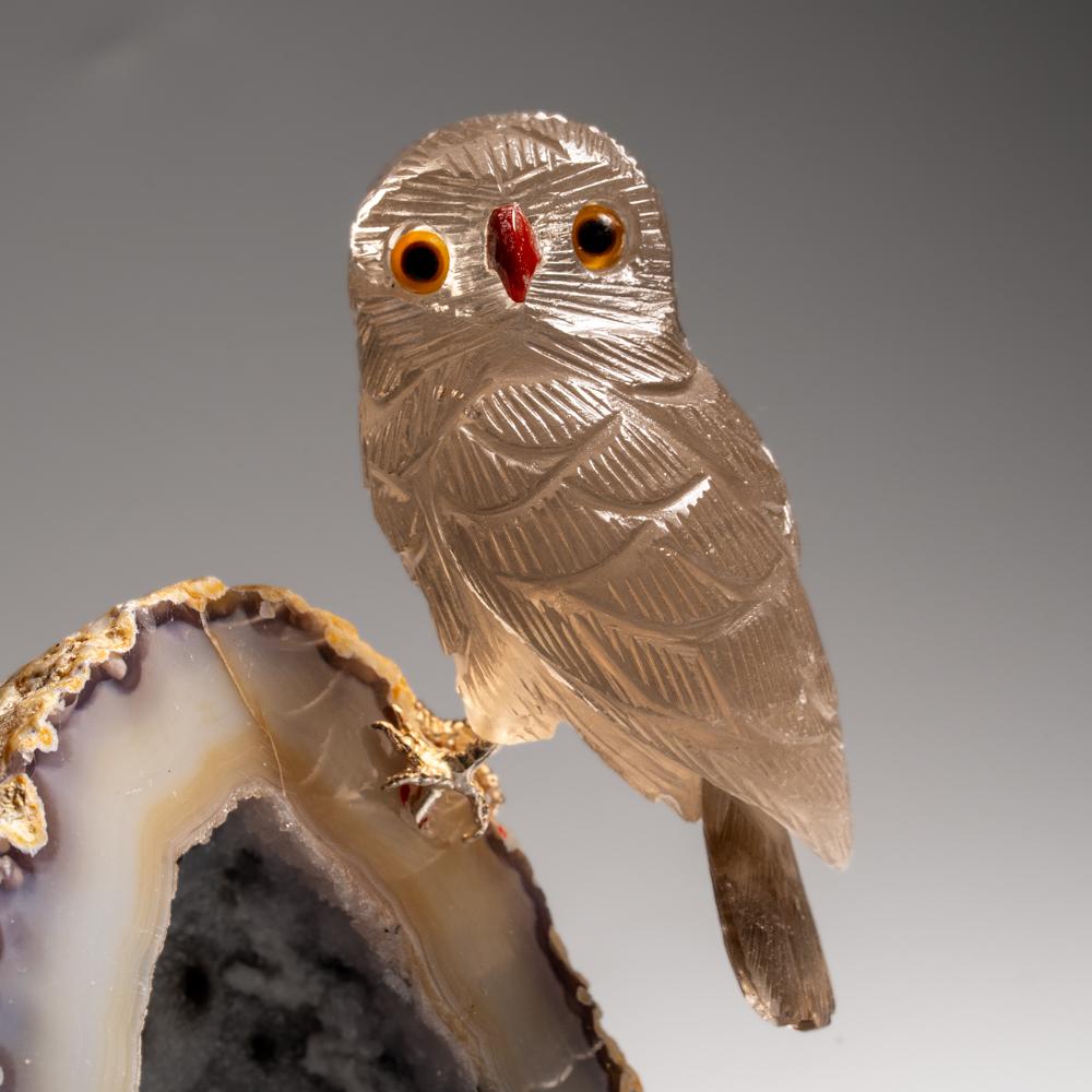 This Owl carving is a unique piece of art, carved from museum-quality smoky quartz with onyx eyes and a carnelian beak. The owl is perched atop a agate quartz geode matrix and mounted on a custom stand for convenient display. This sculpture is