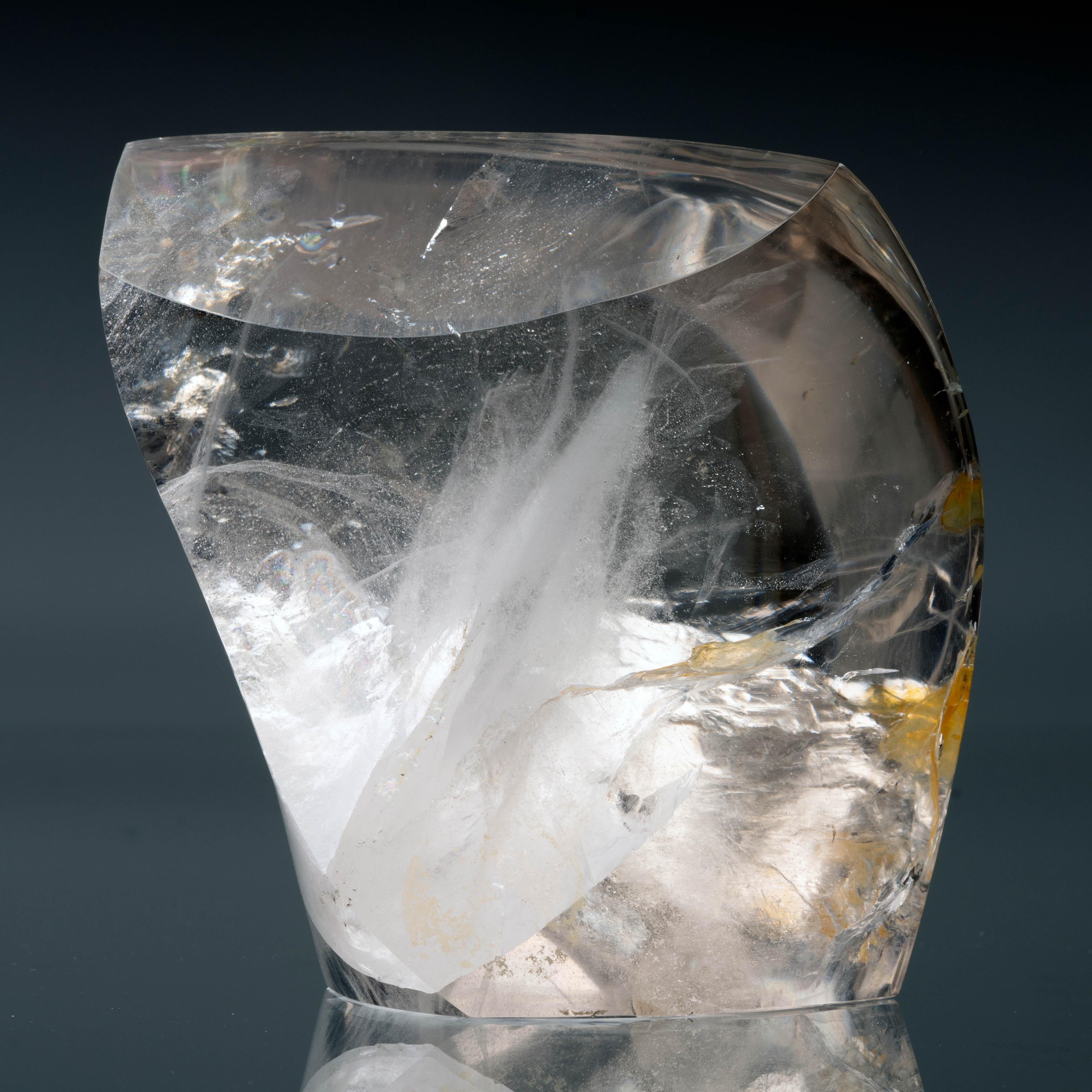 Cette belle forme libre polie à la main en quartz clair lustré du Minas Gerais, au Brésil, présente des inclusions uniques en forme de volutes à l'intérieur. Le Minas est réputé pour avoir produit la plus grande quantité de cristaux de quartz au