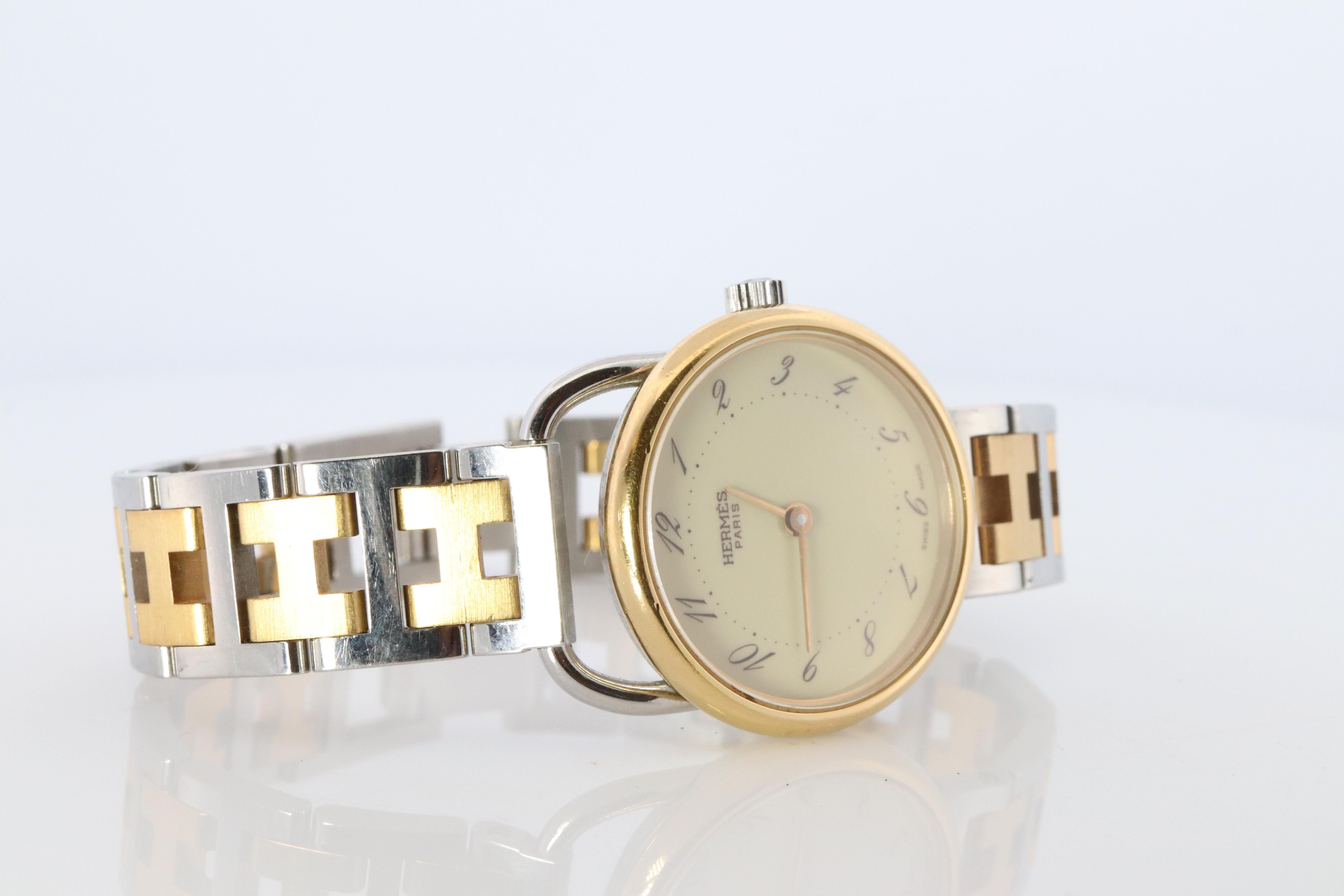 This is an authentic HERMES Arceau 25mm Round Case.

25mm RoundCase
ref. AR3.220

Quartz Movement.


The watch is crafted of stainless steel and 18k plated features a white dial, gold hands and hour markers, two tone link bracelet, sapphire crystal,