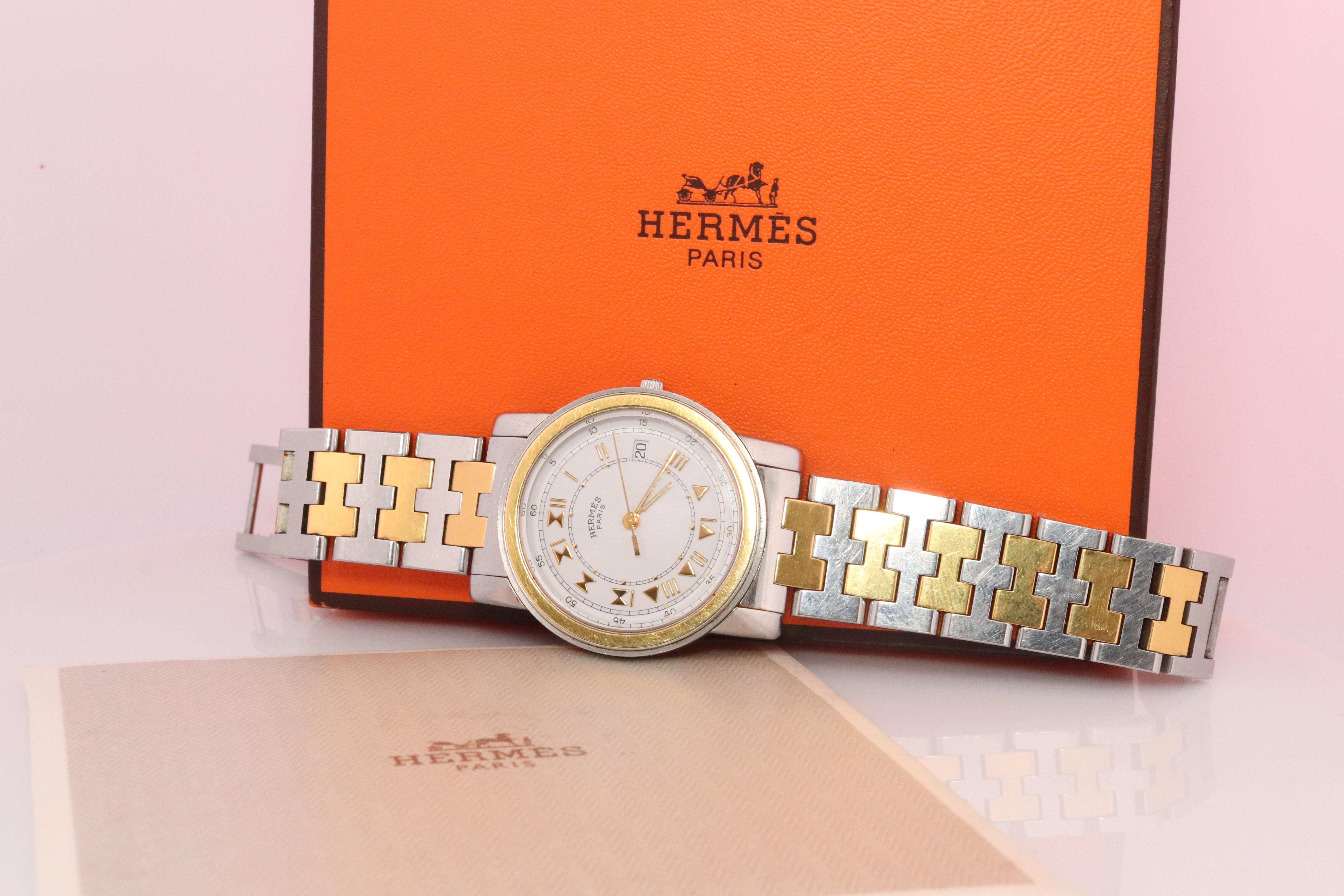 This is an authentic HERMES Carrick 34mm Round Case.

Quartz Movement.

Originally a mens watch but can be unisex

The watch is crafted of stainless steel and 18k plated features a white dial, gold hands and hour markers, sapphire crystal, and a