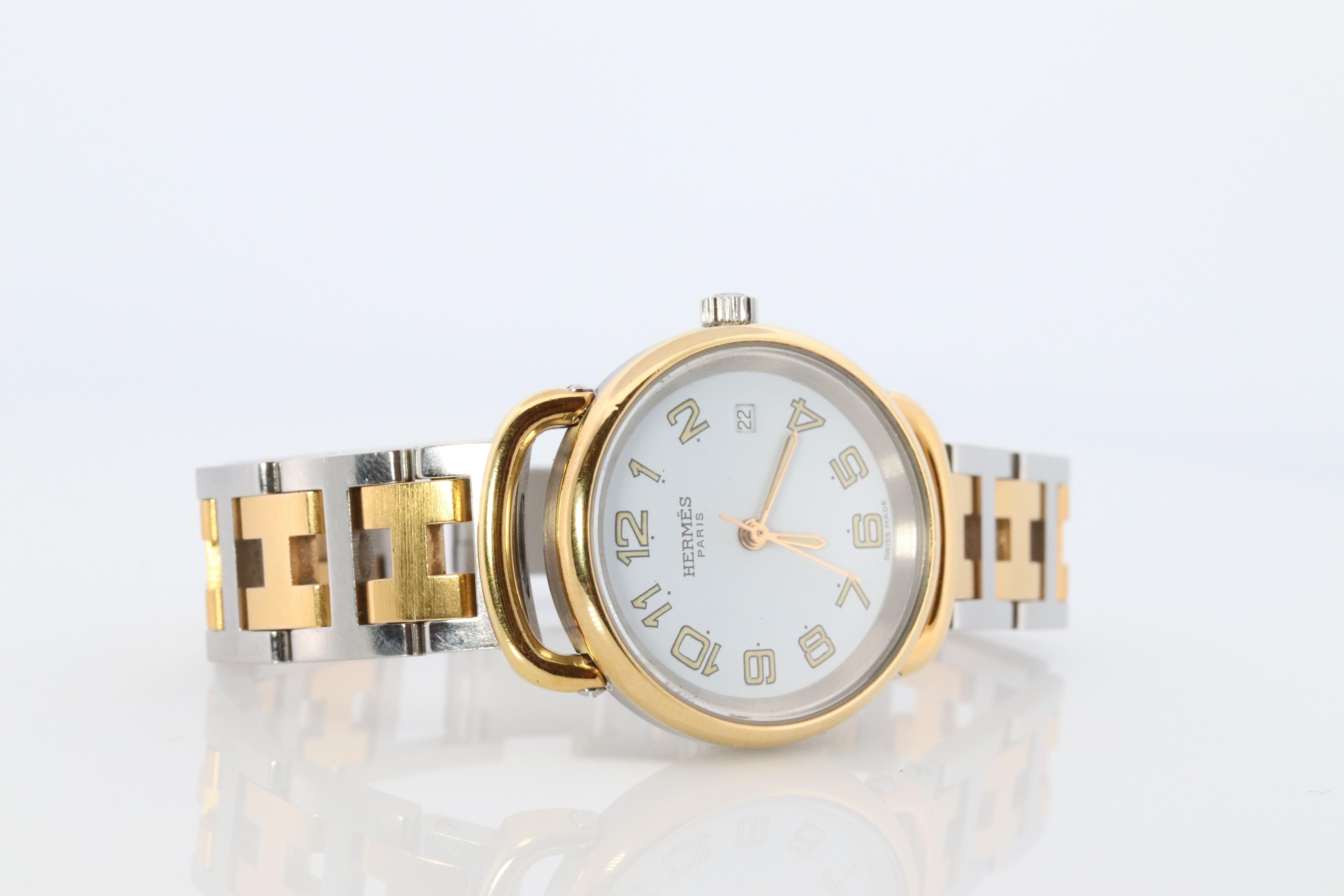 This is an authentic HERMES Stainless Steel 24mm Round Pullman Clipper Quartz r Dial. The watch is crafted of stainless steel and features a white dial, gold hands and hour markers, two tone link bracelet, sapphire crystal, and a quartz