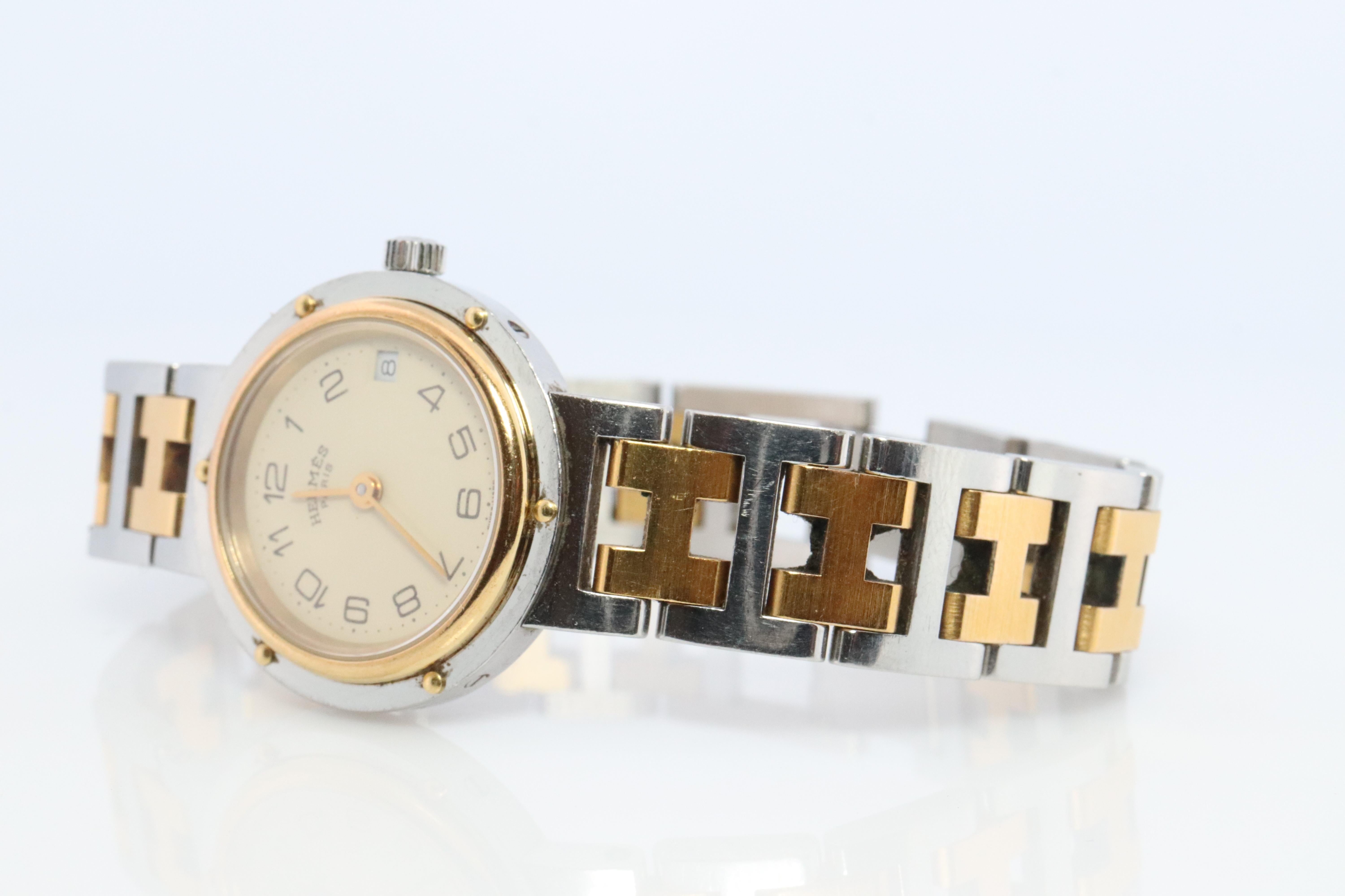 This is an authentic HERMES Stainless Steel 24mm Round Clipper Quartz champagne White. The watch is crafted of stainless steel and features a white dial, gold hands and hour markers, two tone link bracelet, sapphire crystal, and a quartz