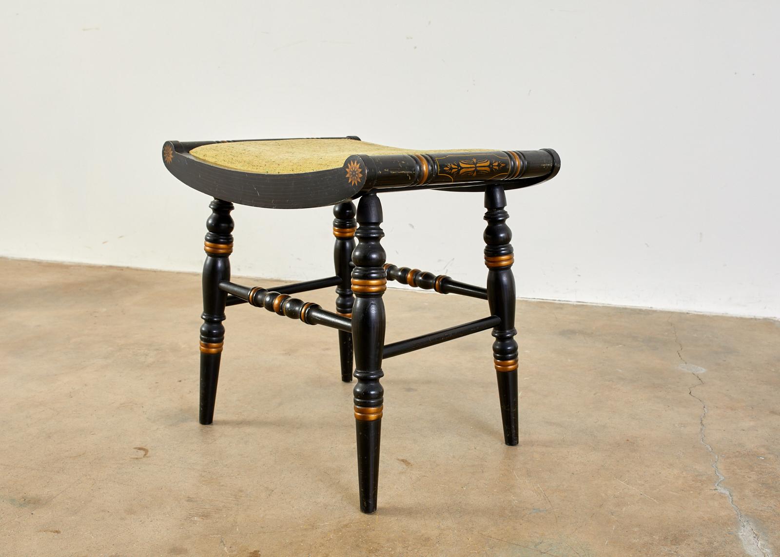 Charming Hitchcock Federal style stool or footstool featuring an ebonized lacquer finish and parcel-gilt stenciling to decorate the chair. Genuine piece made by and signed by Hitchcock with original label affixed on bottom. Curved seat with round