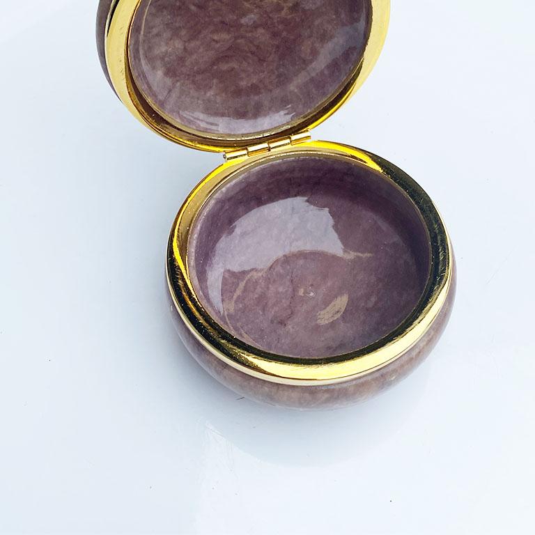 A lovely hand-carved round Italian alabaster trinket box in purple. This piece will be fabulous to display on a coffee table or dressing table. Its hinged lid is in gold and lifts up to reveal the beautiful purple interior. 

Dimensions:
3.25