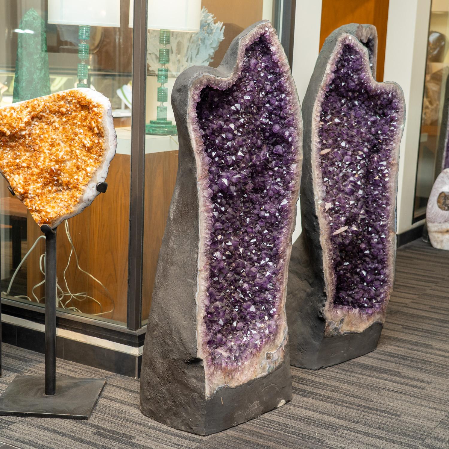 Questo autentico geode a grappolo di ametista proveniente dal Brasile è una formazione naturale di prima qualità di ametista gemmata, ornata da piccoli cristalli di calcite lisci. Il decoro a cattedrale semi-geode mostra cristalli scintillanti,