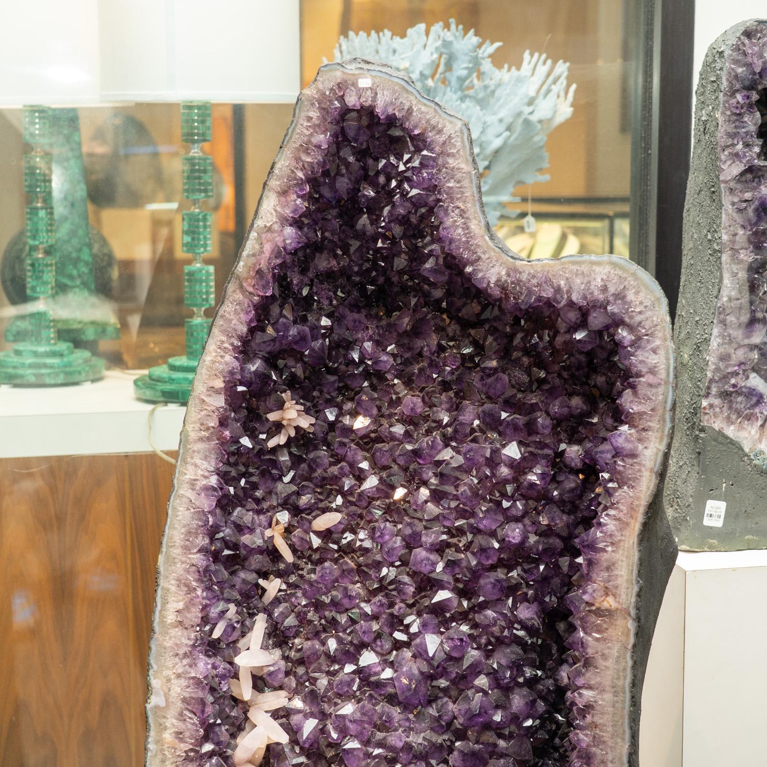 This impressive Amethyst Cluster Geode from Brazil is a high-quality natural formation of genuine amethyst gems. The cathedral decor displays dazzling, fully terminated crystals with reflective surfaces and a rich, translucent grape color. Its