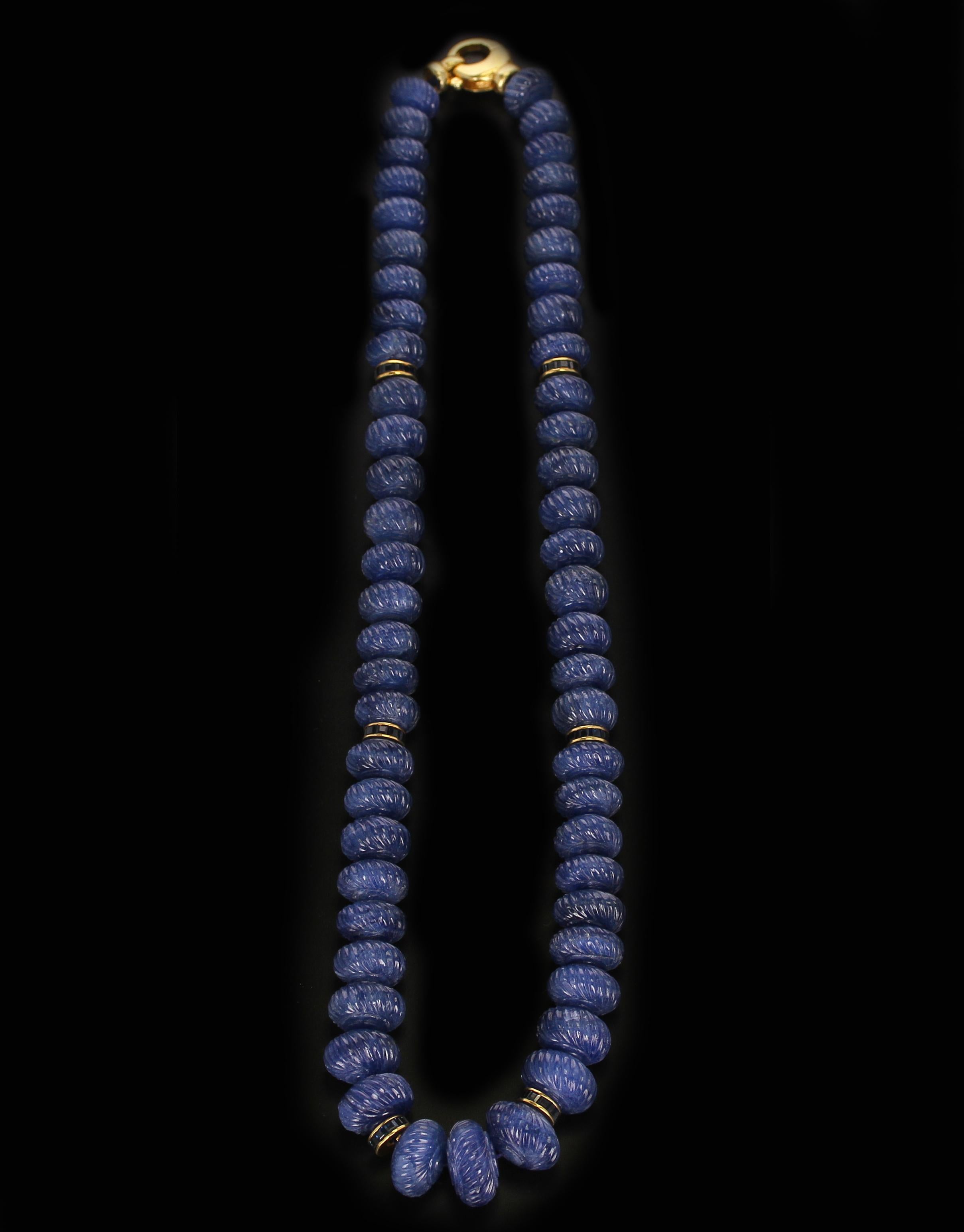 A fine necklace of Genuine & Natural Carved Blue Sapphire Beads with Calibre Sapphire & Gold Spacers. The beads range from 10MM to 15MM and the length is 18.