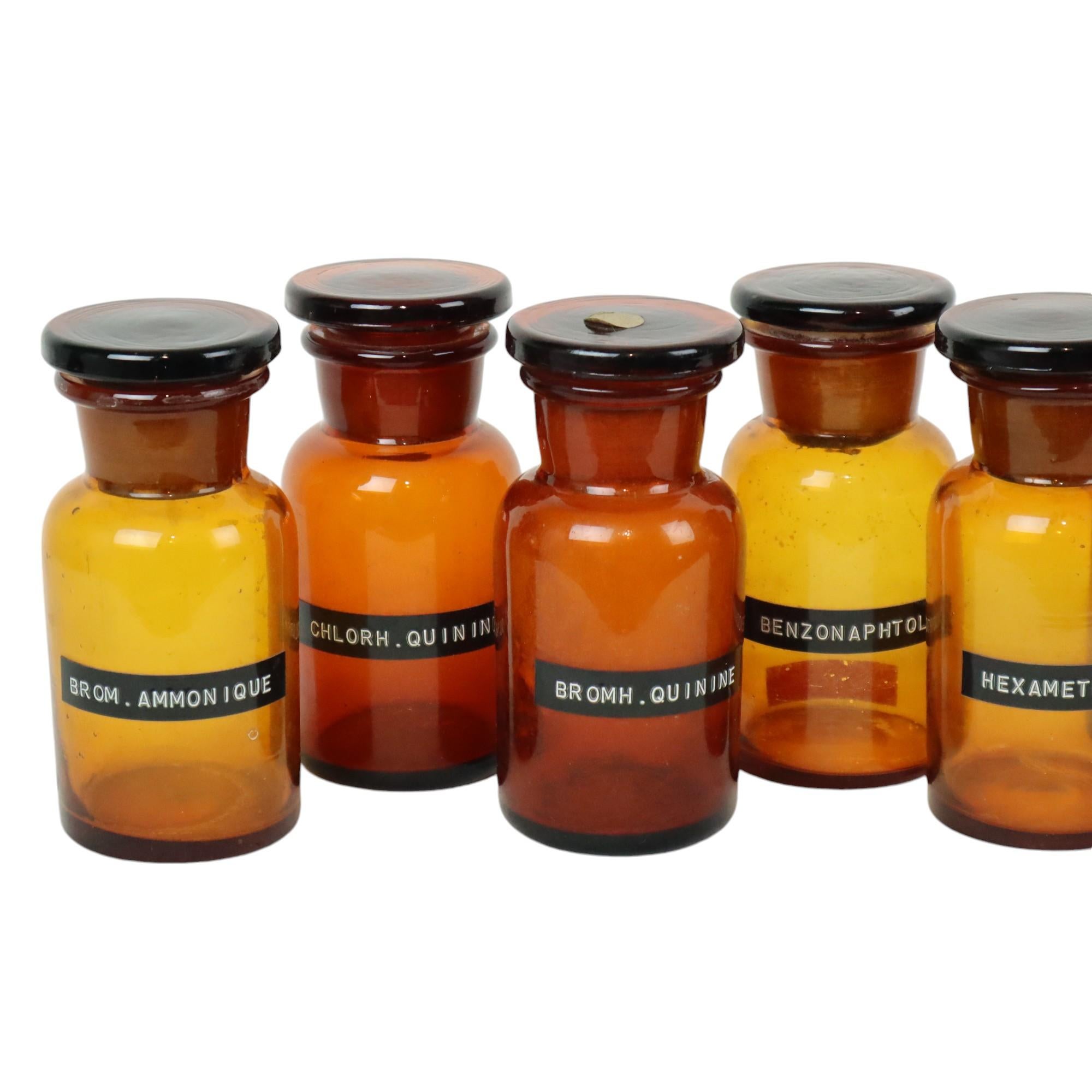 Bel ensemble de 9 authentiques bouteilles ou pots d'apothicaire, en verre soufflé brun ambré avec bouchons en verre épais, circa 1960s-70s.

Cet ensemble a beaucoup de caractère et est rempli de vieux labels et inscriptions, des objets de collection