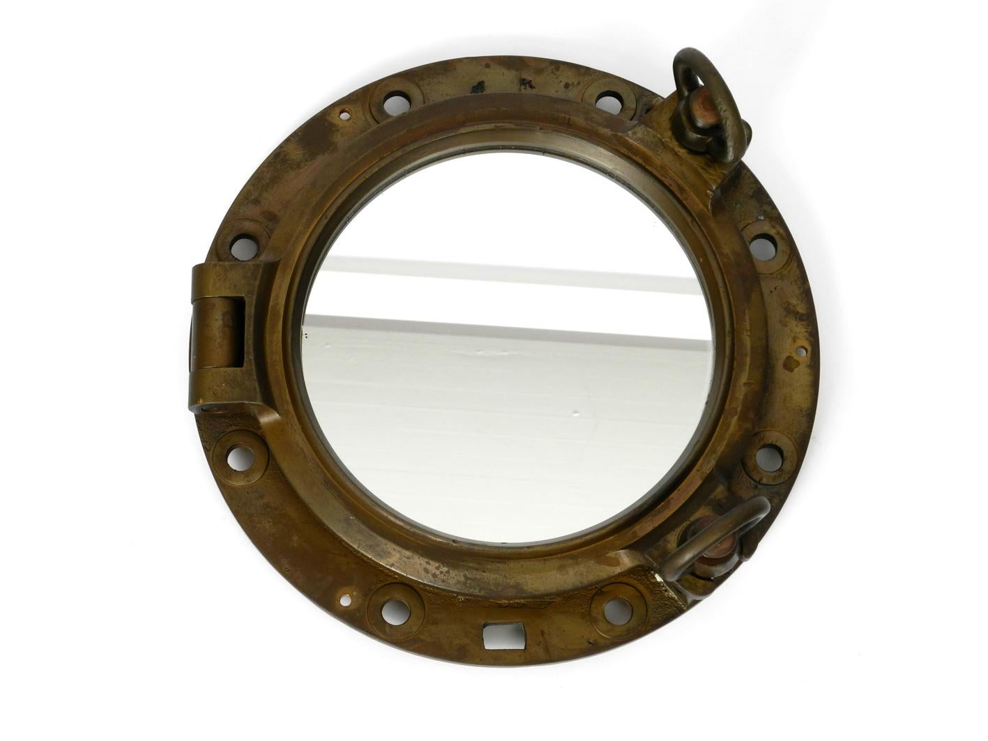 Beautiful rare old brass ship's porthole as a wall mirror.
Very heavy and solid construction. With original screws for opening.
New mirror was sometime before installed. On the back you can see some of it. All parts complete and do work. Certainly