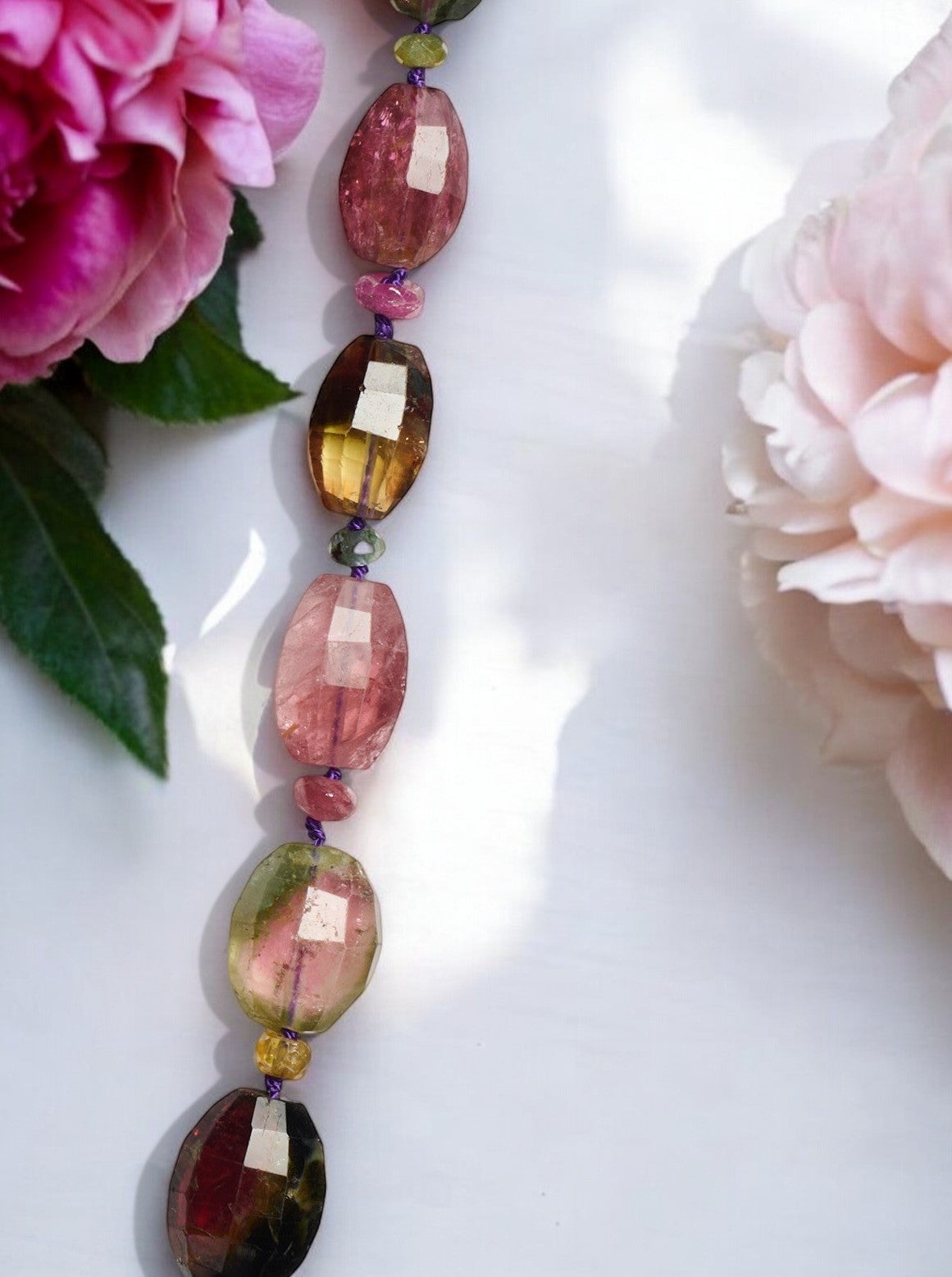 Add a mesmerizing touch to any outfit with this giant graduated tourmaline beaded necklace in 14K solid yellow gold. This handmade necklace is made with a mixture of the finest sapphire and tourmaline beads. The sparkling gemstones capture the light