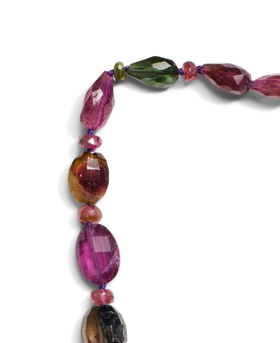 Add a mesmerizing touch to any outfit with this giant graduated pink tourmaline beaded necklace in 14K solid yellow gold. This handmade necklace is made with a mixture of the finest hand carved sapphire and tourmaline beads. The sparkling gemstones