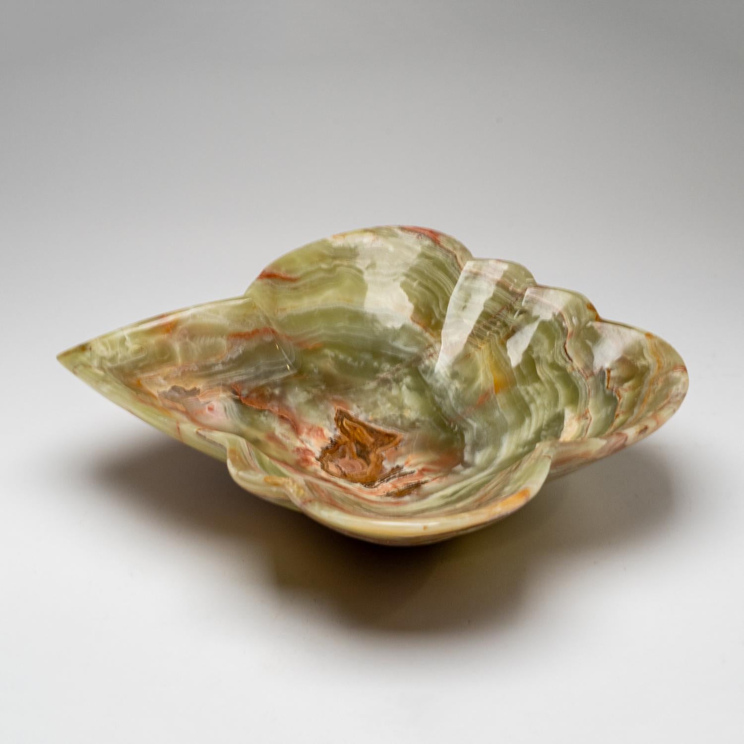 Diese einzigartige dekorative Schale in freier Form, die aus einem einzigen Stück natürlichen Onyx gefertigt ist, besticht durch ihre hochglanzpolierte Oberfläche und ihre satten, erdigen Farbtöne, die Weiß-, Honig- und Brauntöne mischen. Mit seinem