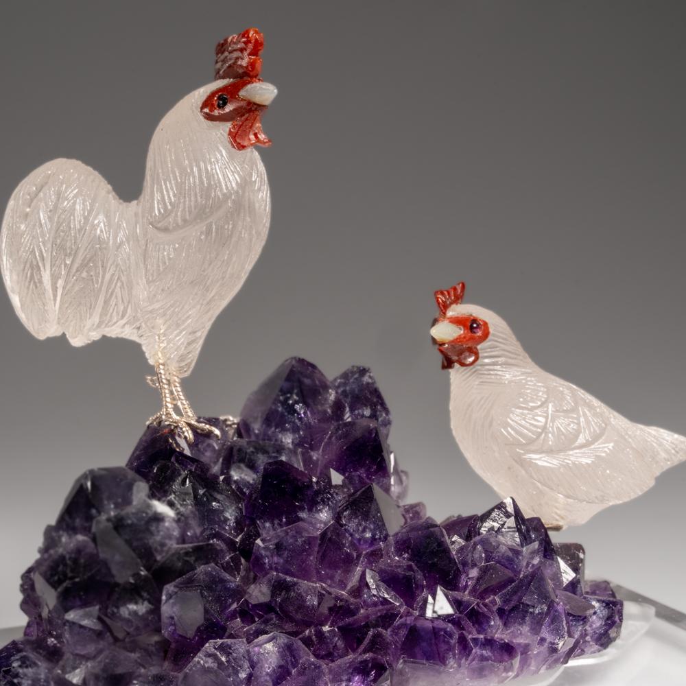 This rooster and chicken carving is a unique piece of art, carved from museum-quality quartz with carnelian eyes. The roosters is perched atop an amethyst geode matrix and mounted on a custom stand for convenient display. This sculpture is