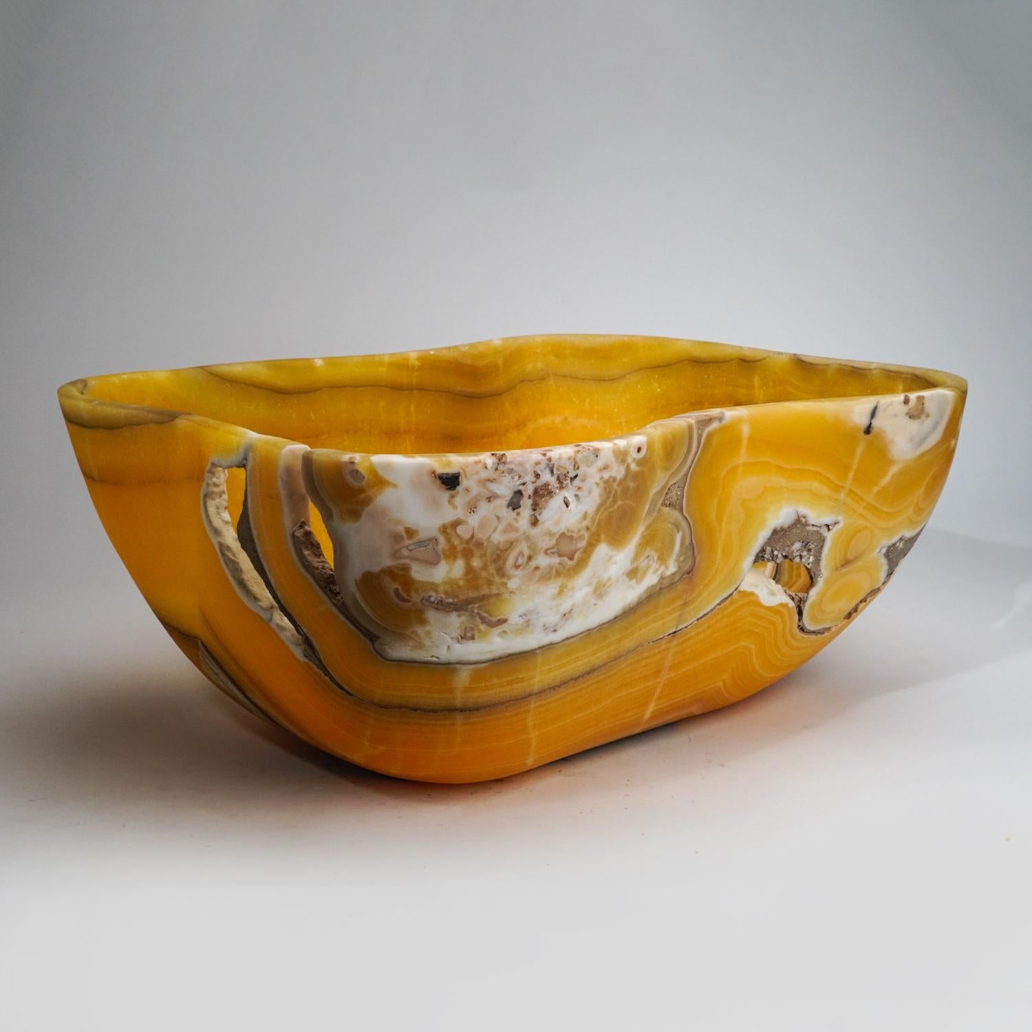 Large, one-of-a-kind, free-form natural onyx decorative bowl carved out of a single chunk of banded natural onyx. This incredible piece is polished to a mirror finish. This unique piece blends natural onyx shades of orange, white, honey and blue