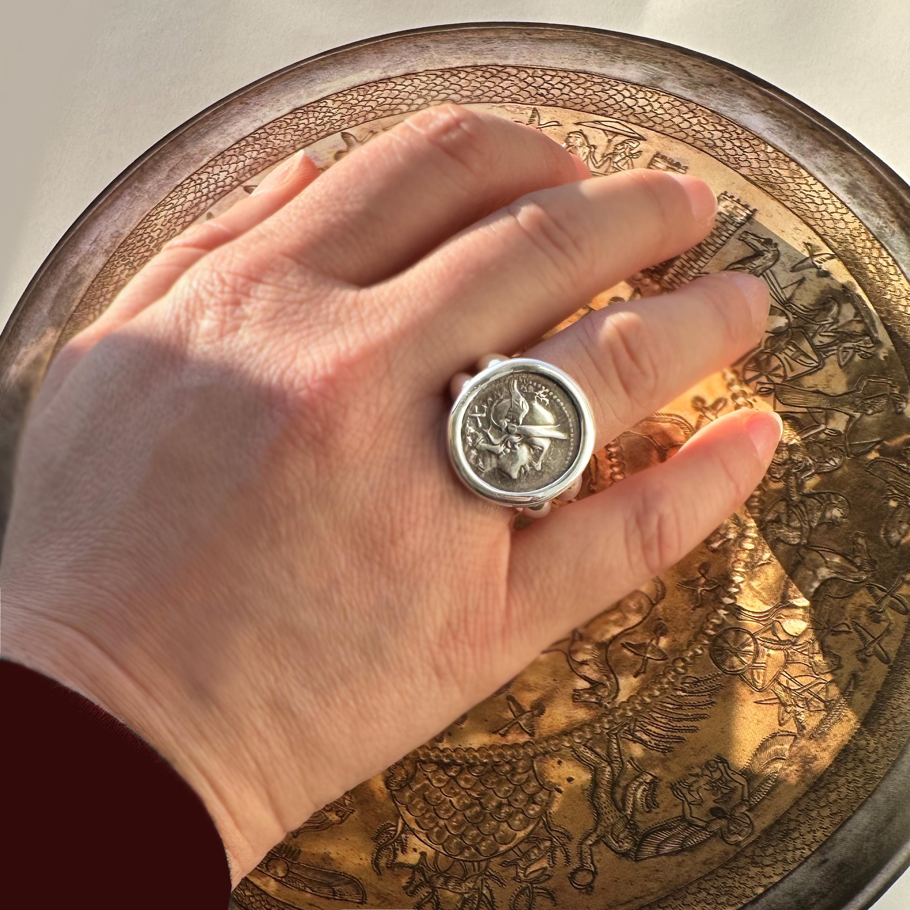 This stunning 18 kt gold ring showcases an authentic silver Roman coin, specifically a sestertius from 211 BC, featuring a depiction of the Goddess Rome. Meticulously crafted, this ring is a testament to artistic skill and attention to detail. The