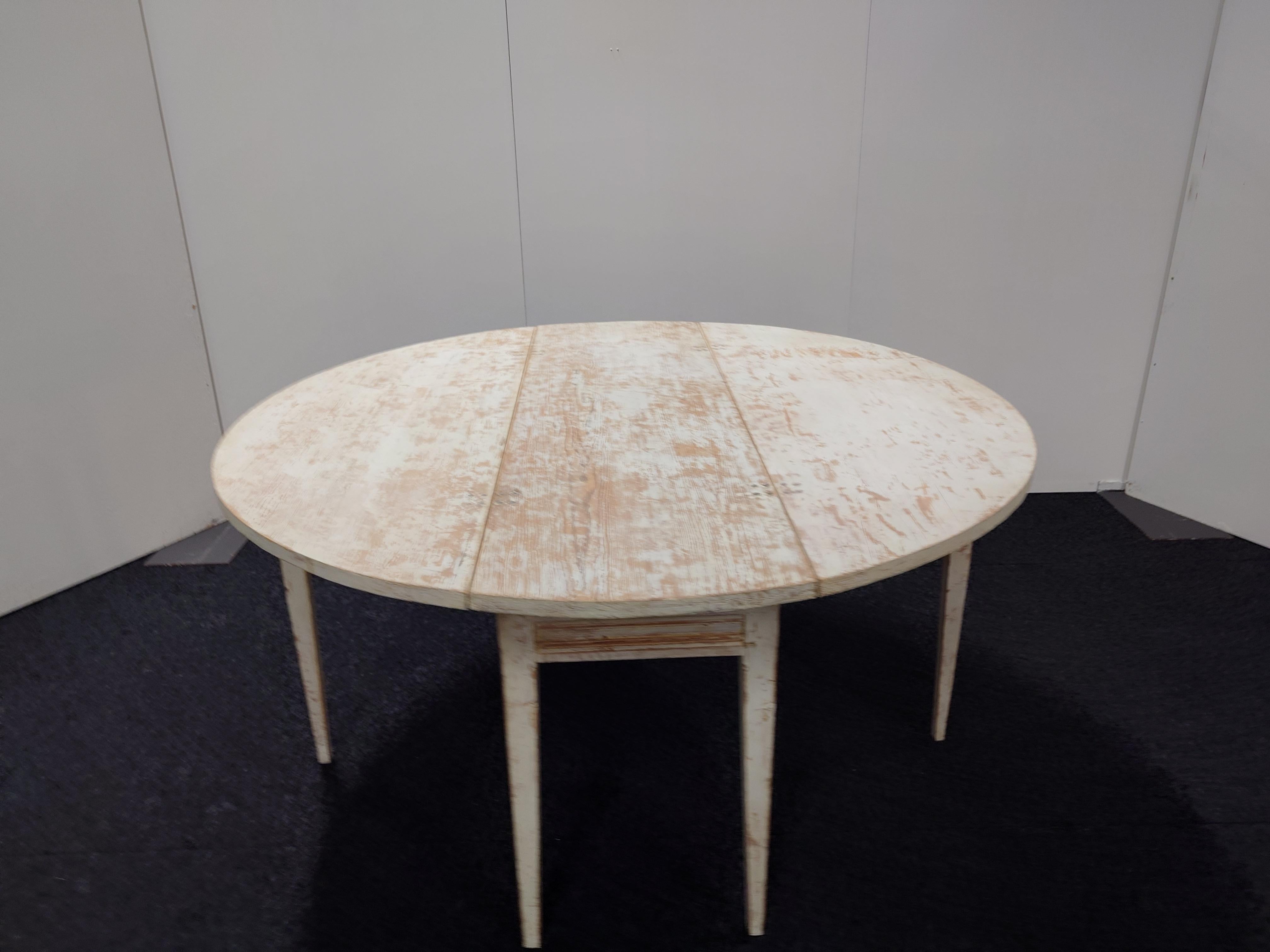 Authentique table à pieds tombants de style gustavien fabriquée vers 1790 à 1810 en  Luleå Norrbotten, dans le nord de la Suède. Le cadre est en pin massif et présente la peinture d'origine, avec des traces d'usure et une patine d'usage. Double