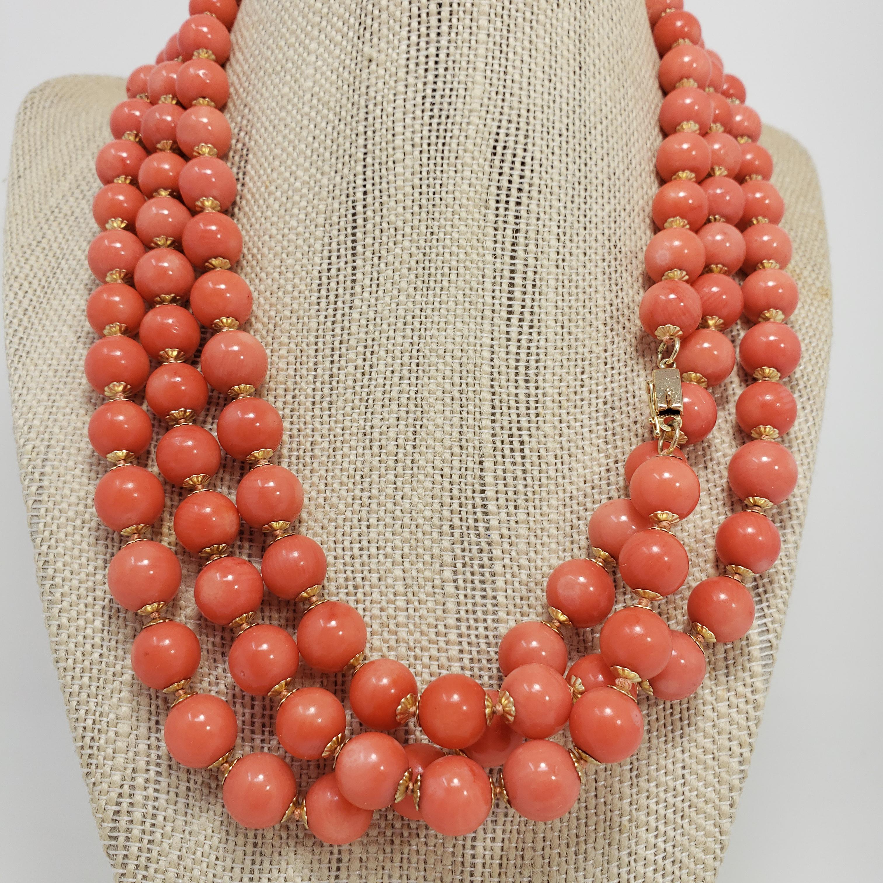 An extravagant and stylish necklace. Features 10mm salmon coral beads decorated with 14K yellow gold accents and fastened with a 14K yellow gold clasp. The impressive 145cm length make this a versatile accessory, which can be worn single or double