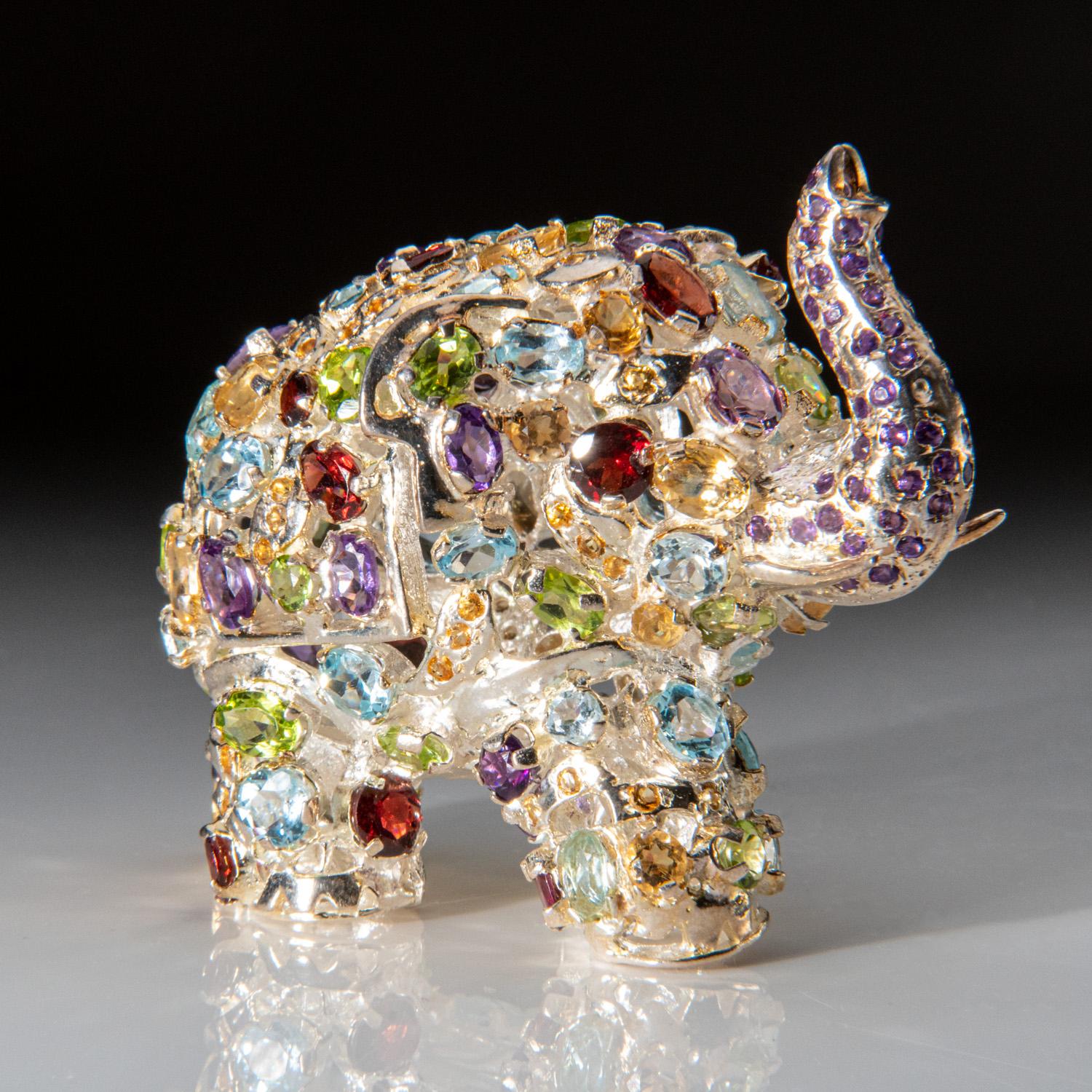 Cette sculpture d'éléphant unique en argent sterling est fabriquée à la main en Inde. Fabriqué en argent sterling véritable, il est parsemé de pierres précieuses, dont le grenat rouge, le paridot, l'améthyste, la citrine et la topaze bleue, pour une