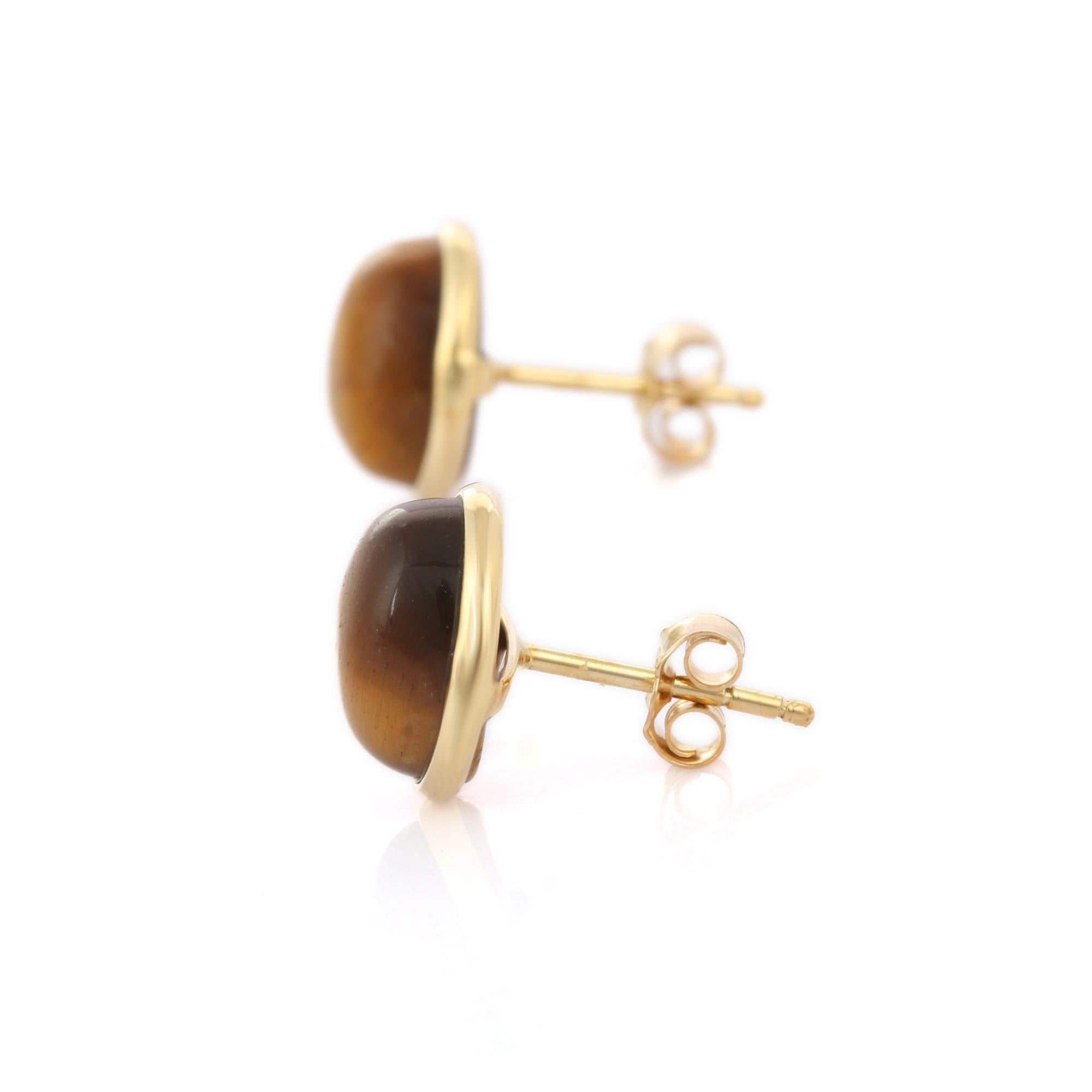 Studs create a subtle beauty while showcasing the colors of the natural precious gemstones making a statement.
Oval cut genuine tiger's eye cabochon stud earrings in 18K gold. Embrace your look with these stunning pair of earrings suitable for any