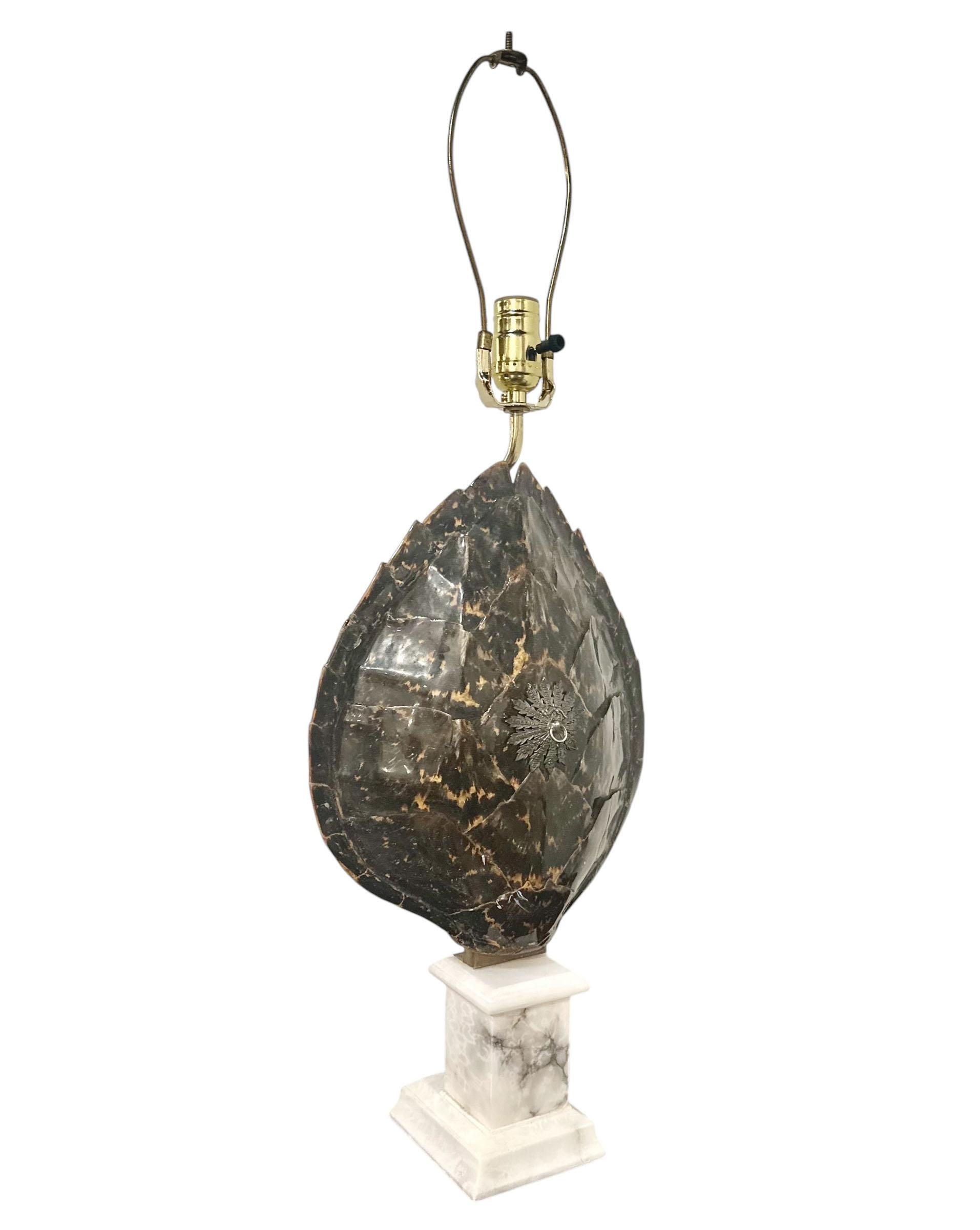 An extraordinary real tortoiseshell lamp, crowned with a silver medallion at its center. The shell gracefully rests on a five inch round marble base. Newly wired with updated plug and fittings. Rich in tone and presence, this lamp is a rare treasure