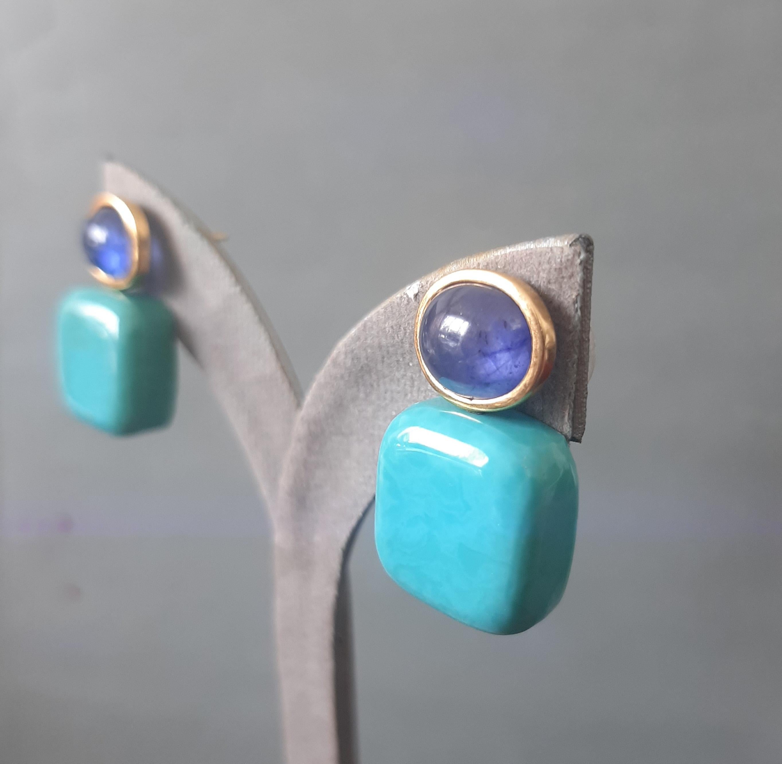 Questi semplici ma eleganti orecchini fatti a mano hanno 2 zaffiri blu cabochon di 8 x 10 mm incastonati in un castone d'oro giallo 14 Kt alla cui sommità sono sospesi 2 turchesi autentici a forma di cuscino di 15 x 15 mm.

Nel 1978 il nostro
