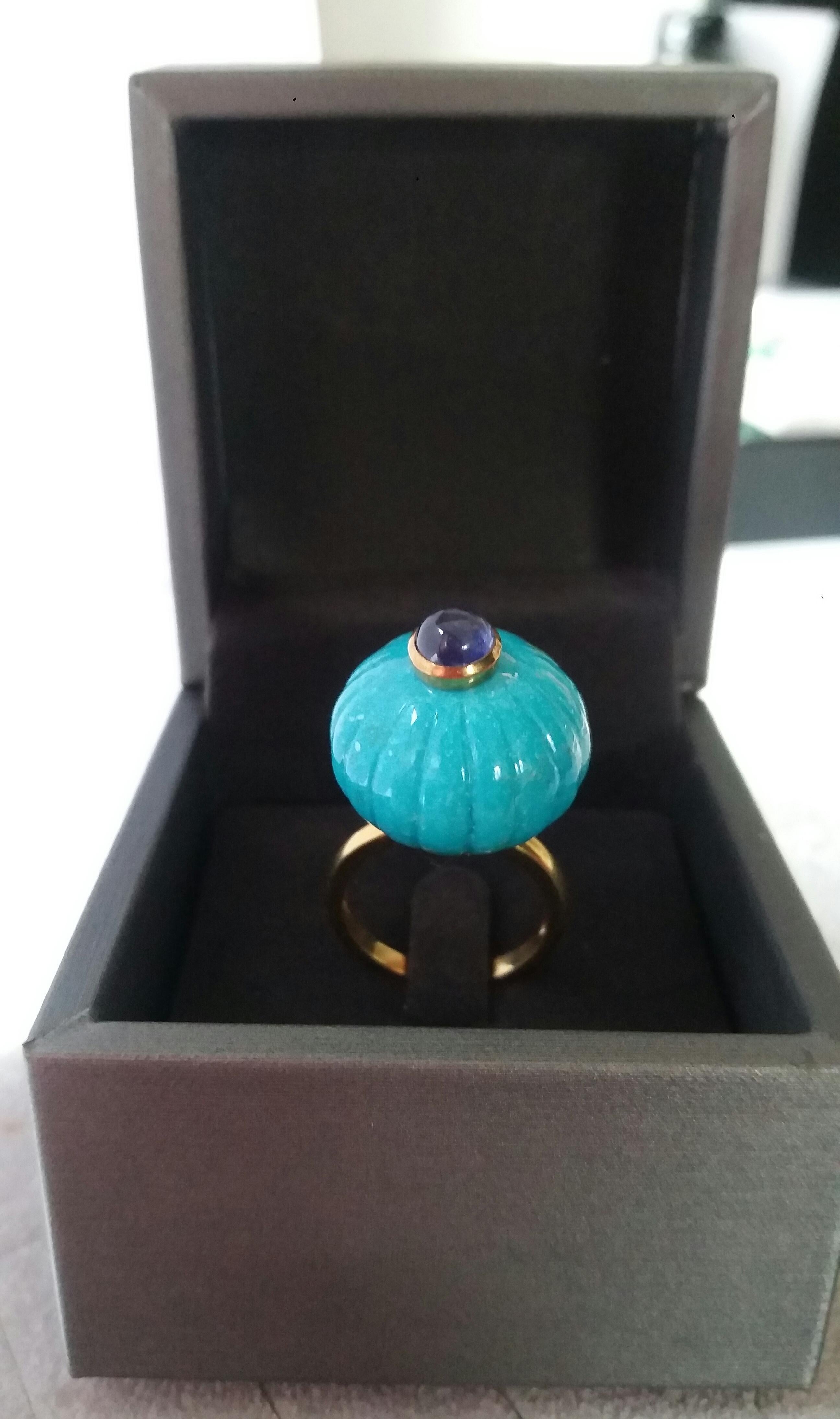 Melon cut Turquoise Round Bead  of 21 mm. in diameter and 16 mm. thick with in the center a round Blue Sapphire cabochon of 8 mm. in diameter  is mounted on top of a 14 Kt. yellow gold shank.
In 1978 our workshop started in Italy to make simple-chic