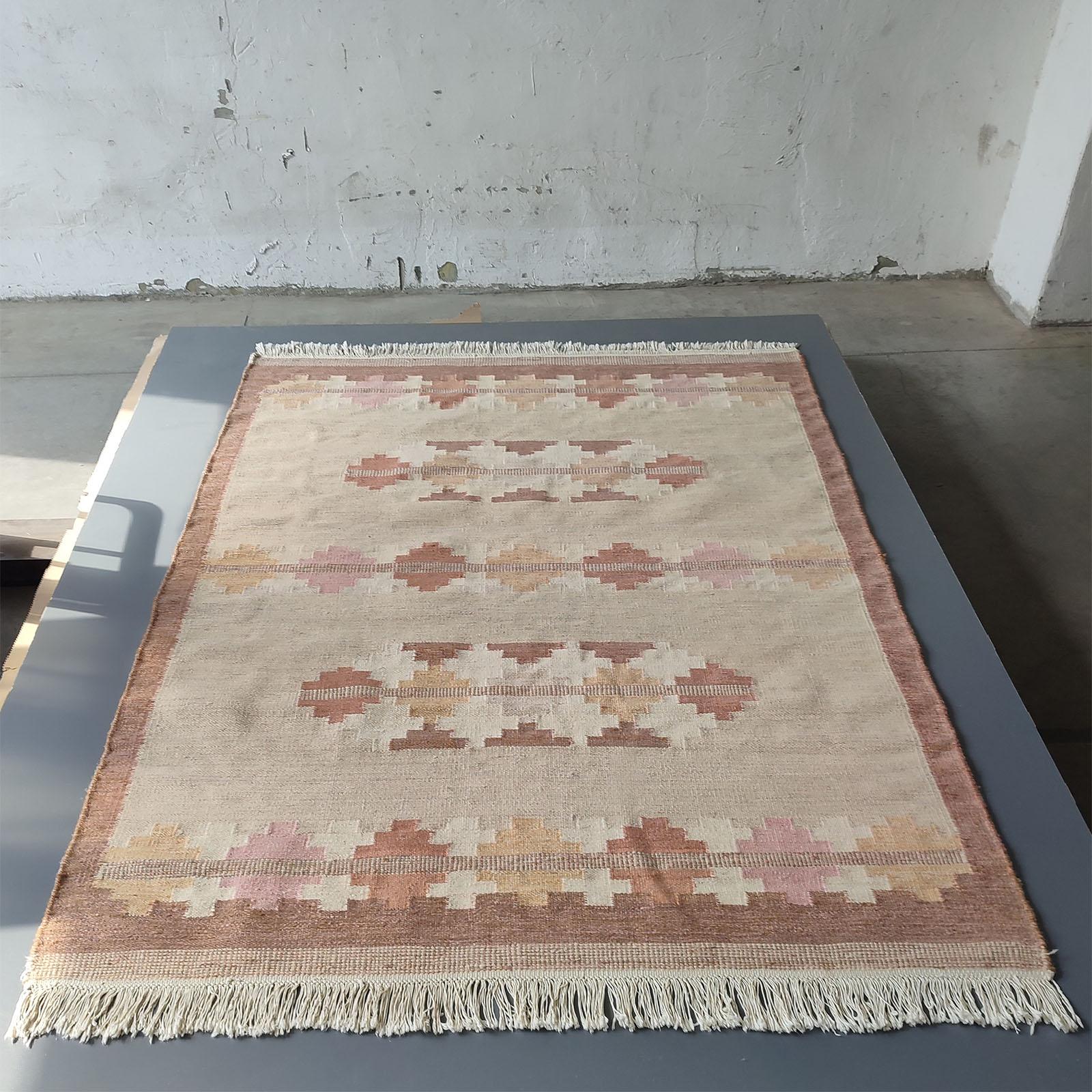 Genuine vintage Scandinavian Kilim rug. Rare find and never seen in this color pallette.
The color palette comprises of gentle shades of beige, rusty faded red, brown and pink, against a neutral beige, in complementary geometric shapes that