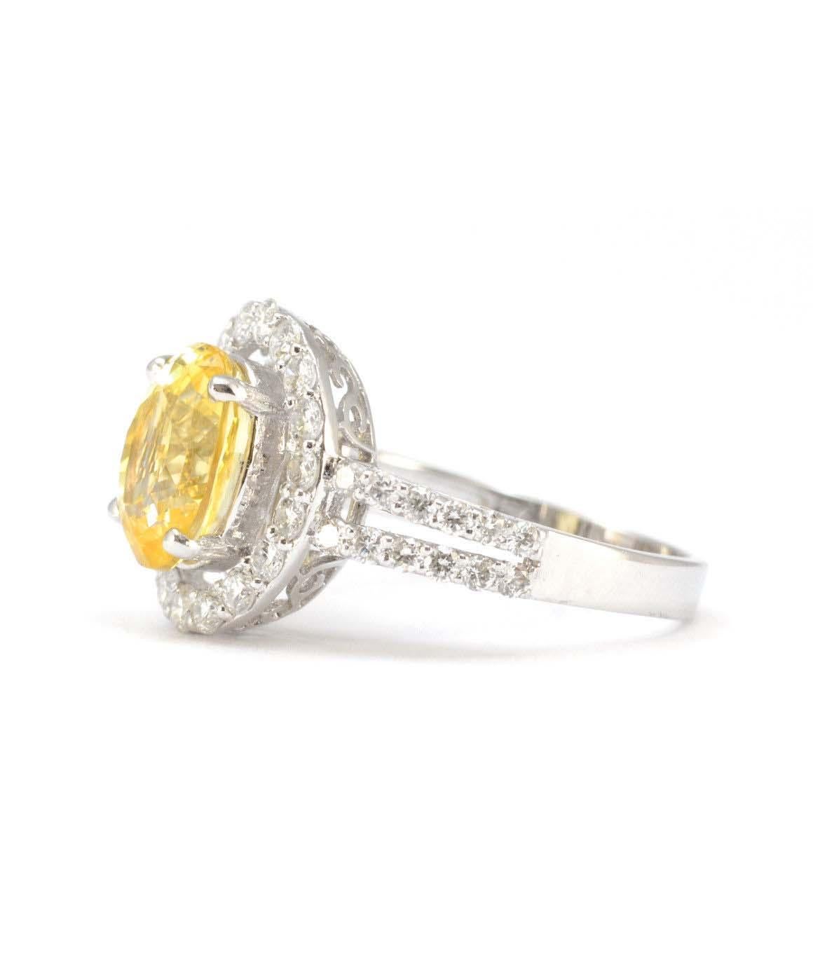 This is a gorgeous genuine yellow sapphire & natural diamond ring in excellent condition! The oval yellow sapphire measures 9.96mm X 7.96mm approximately. There are 18 round brilliant diamonds in the halo, F VS weighing approximately 0.55CTTW. There