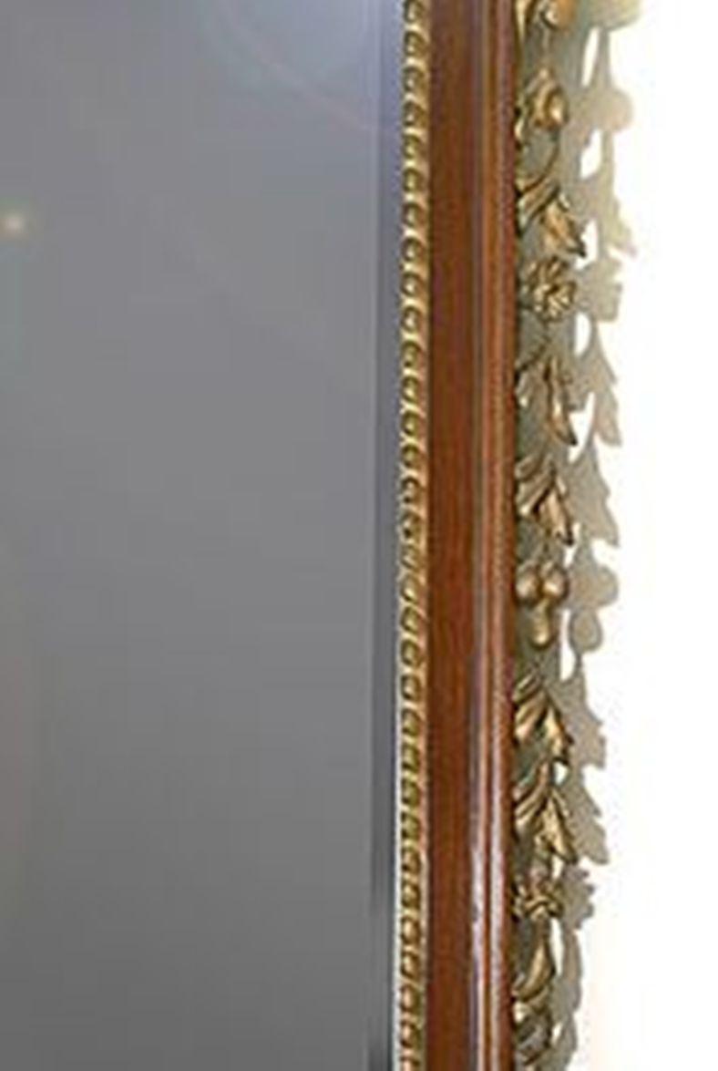 An early 20th century Geo 111 style mahogany and giltwood framed mirror.
The rectangular and bevelled mirror plate surmounted by a carved giltwood Prince of Wales feathers crest.